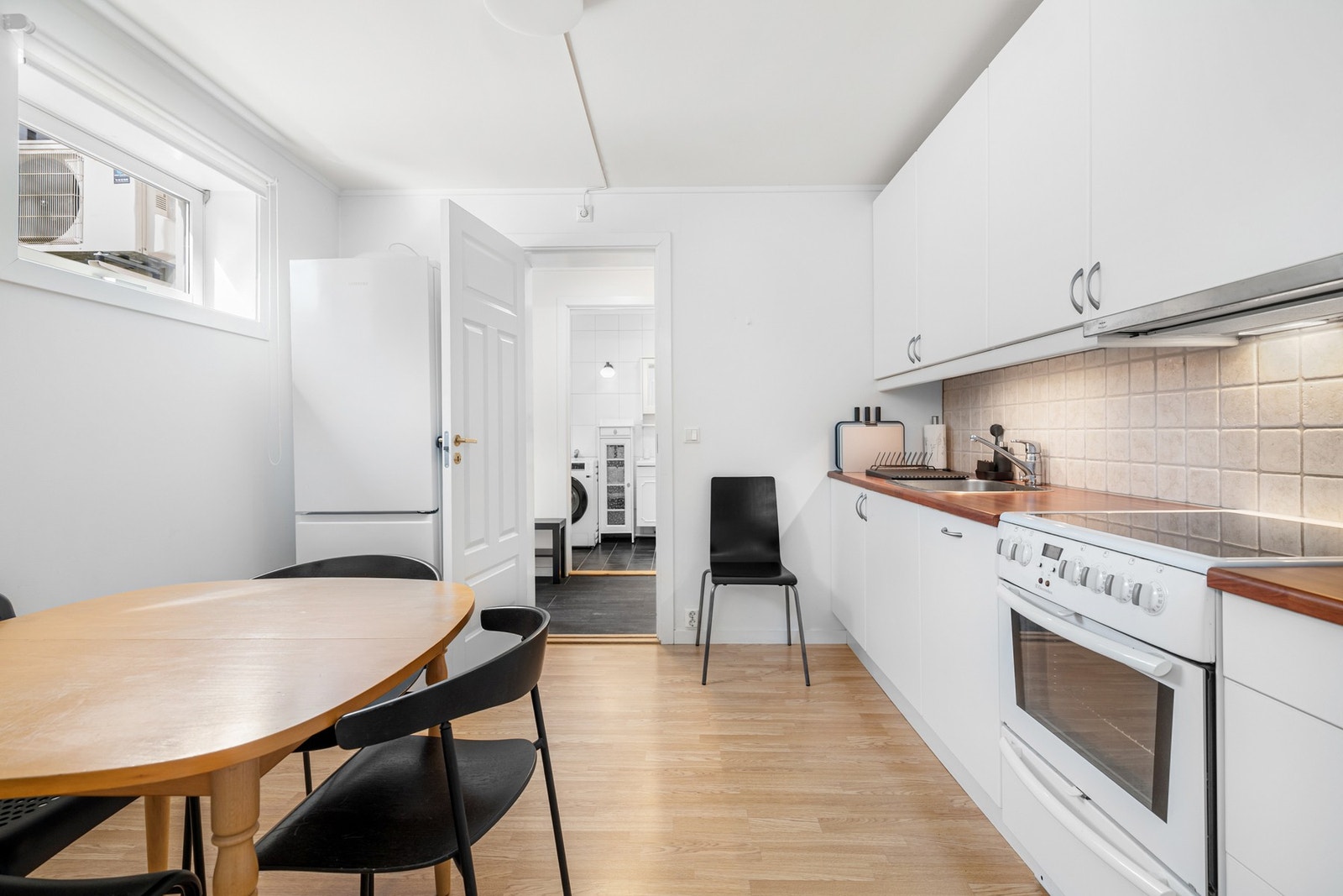 Kjøkken med spiseplass i hybeldelen. Det gjøres oppmerksom på at dette rommet er definert som bod i byggetegningen, og er derfor ikke godkjent for varig opphold. Galleribilde