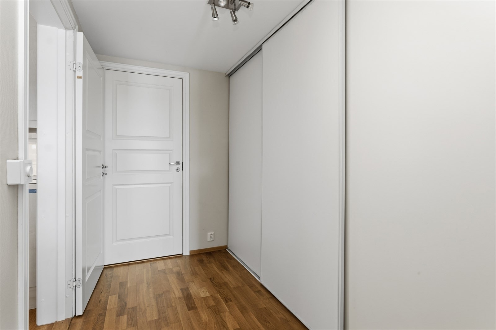 Praktisk garderobegang leder inn til både soverom 2 og innerboden. Her er det tre-dørs plassbygget skyvedørsgarderobe med takhøye dører som rommer massevis av oppbevaringsplass. Galleribilde