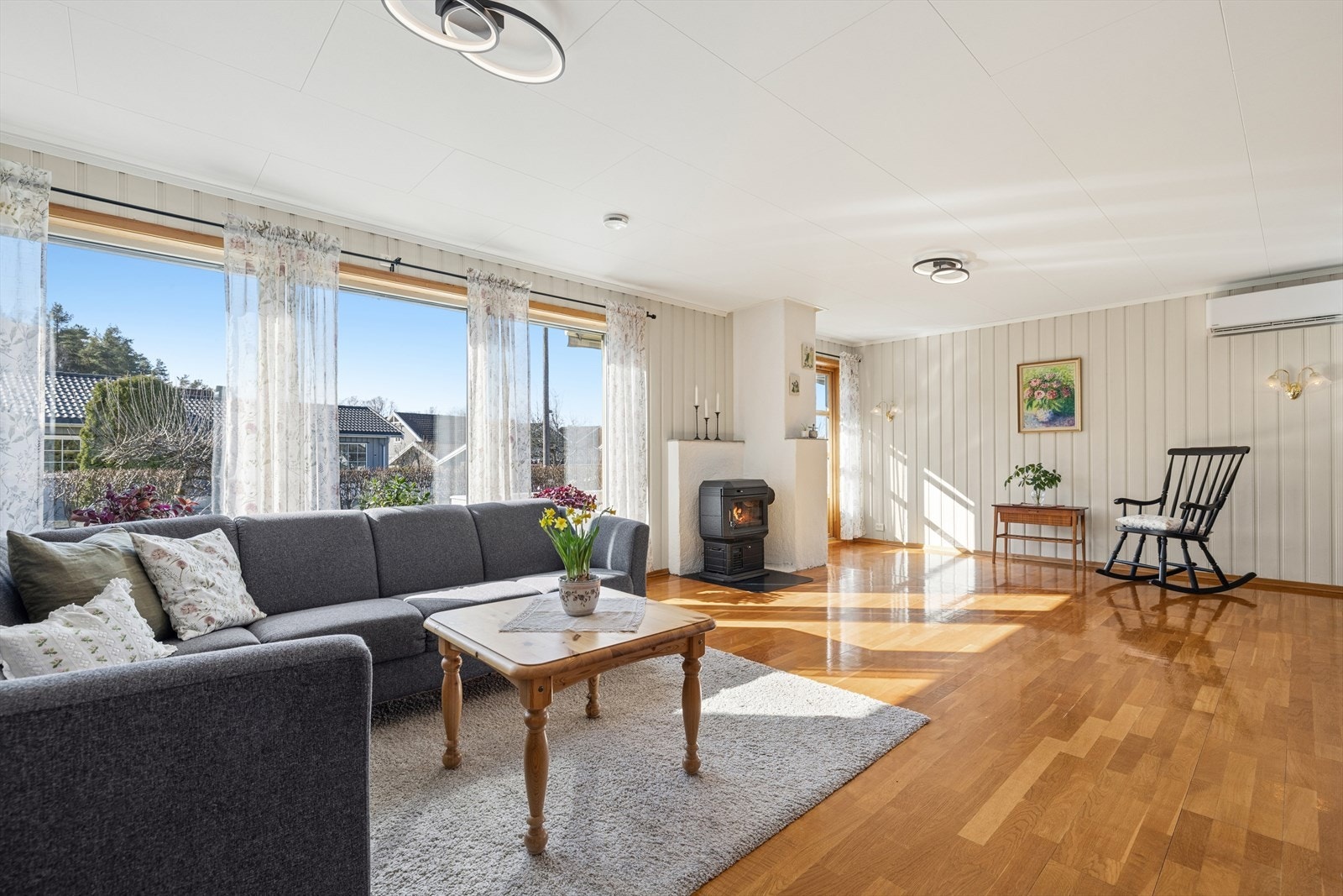 Store vinduer sørger for rikelig med naturlig lys til stuen. Galleribilde