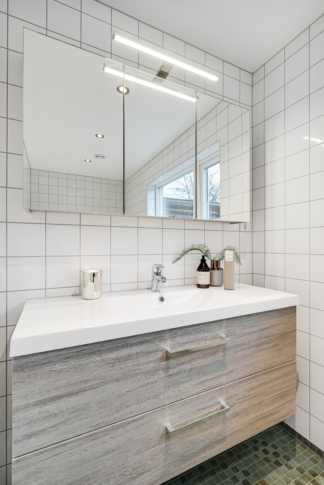 Baderomsinnredning med nedfelt servant og speilskap med integrert belysning. Galleribilde