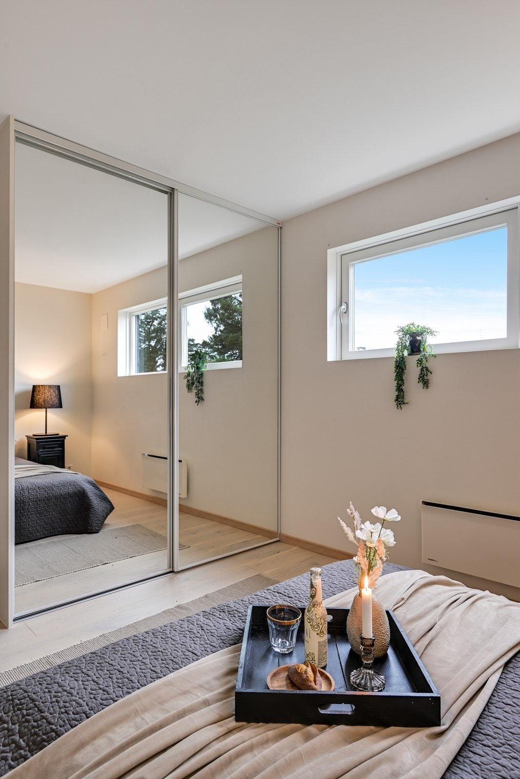 En skyvedørsgarderobe med speilfronter gir rikelig med oppbevaringsplass og bidrar til romfølelsen. Galleribilde
