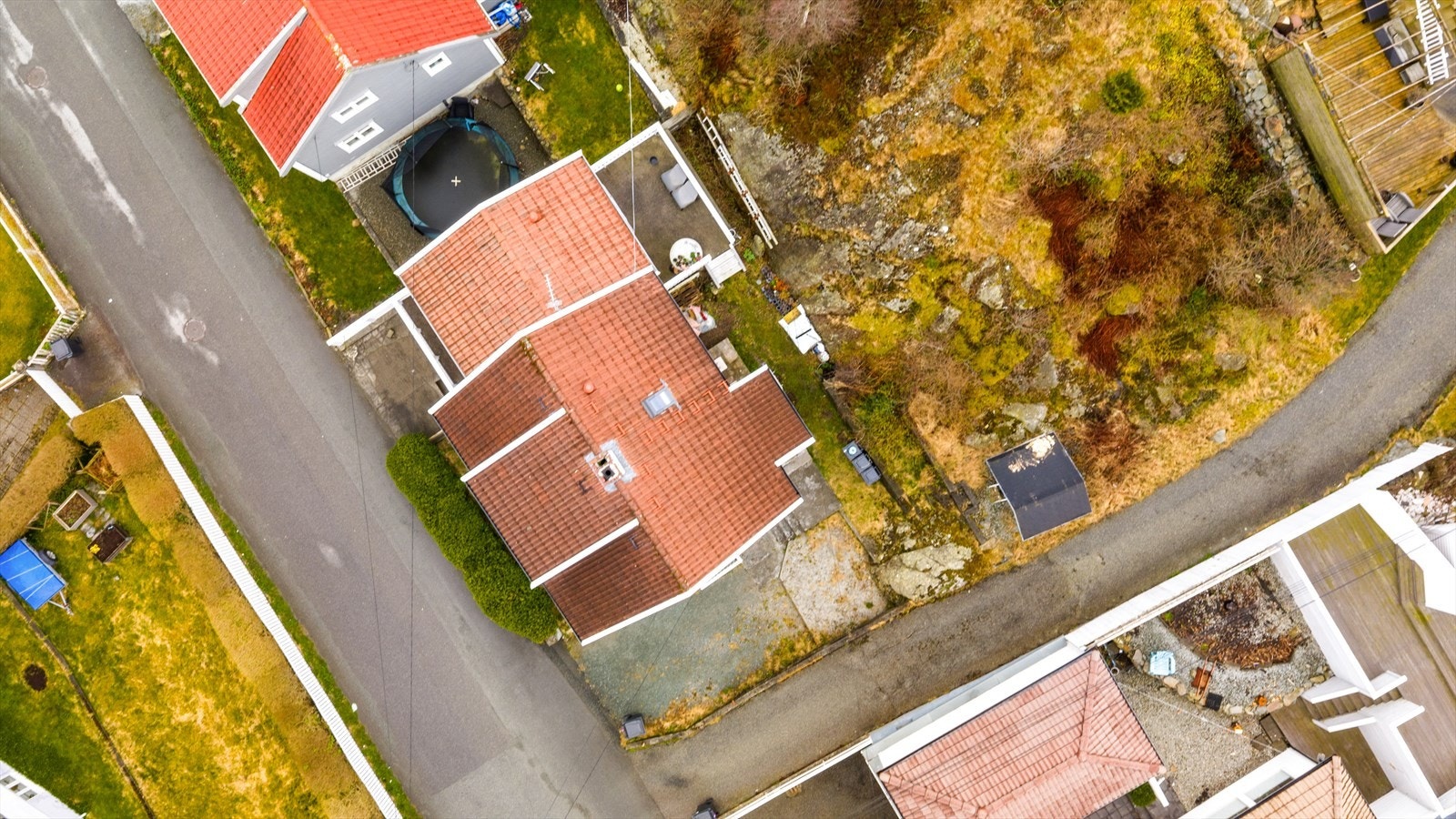 Tomten er opparbeidet med gruset gårdsplass, stor terrasse og variert beplantning- tomten strekker seg også godt opp på fjellet på baksiden av huset (se grunnkart i salgsoppgaven) Galleribilde