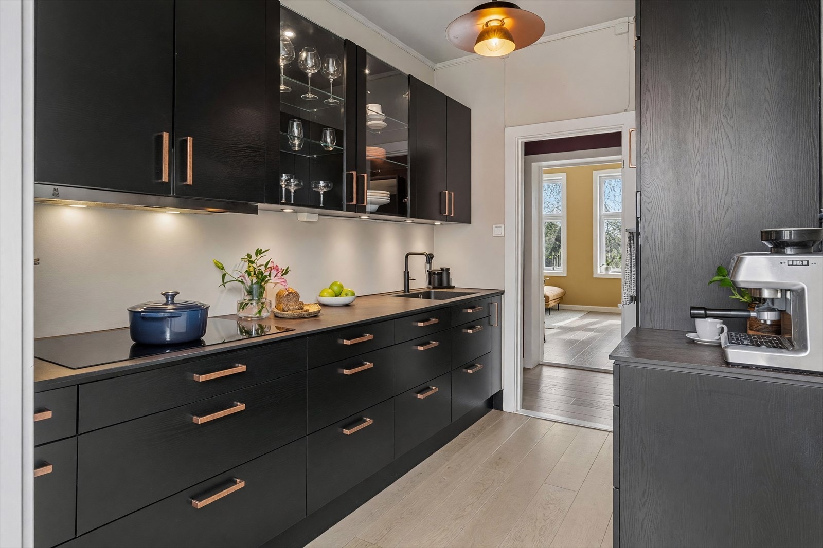 Stilrent Aubo-kjøkken fra 2020 med glatte fronter kombinert med elegante glassfronter og benkeplate i slitesterk kompositt. Med handelen følger platetopp, stekeovn, oppvaskmaskin og kjøl/fryseskap. Galleribilde