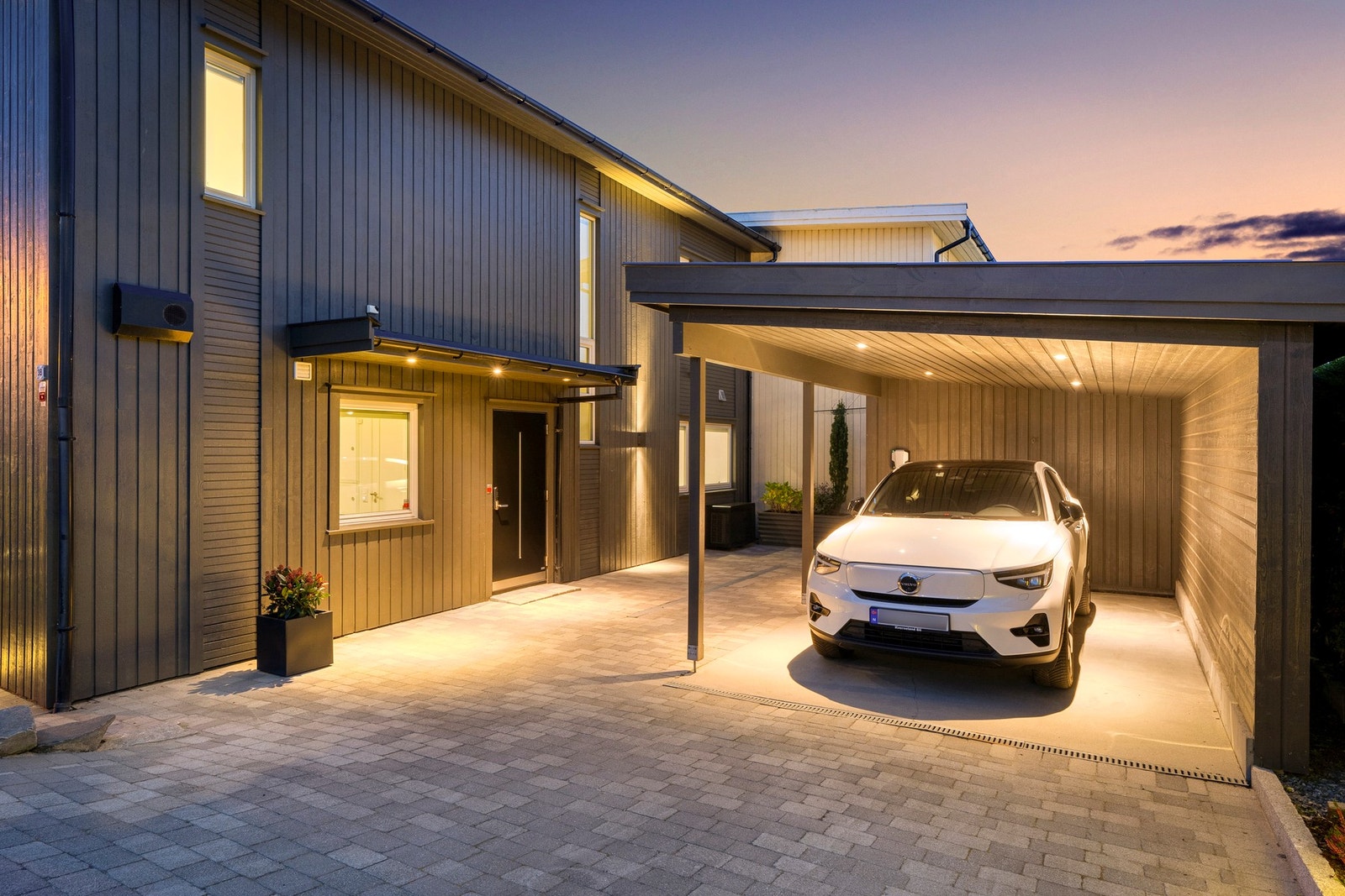 Det er svært gode parkeringsmuligheter på eiendommen med stor steinlagt innkjørsel som gir plass til flere biler, i tillegg til carport m/ elbil lader. Galleribilde