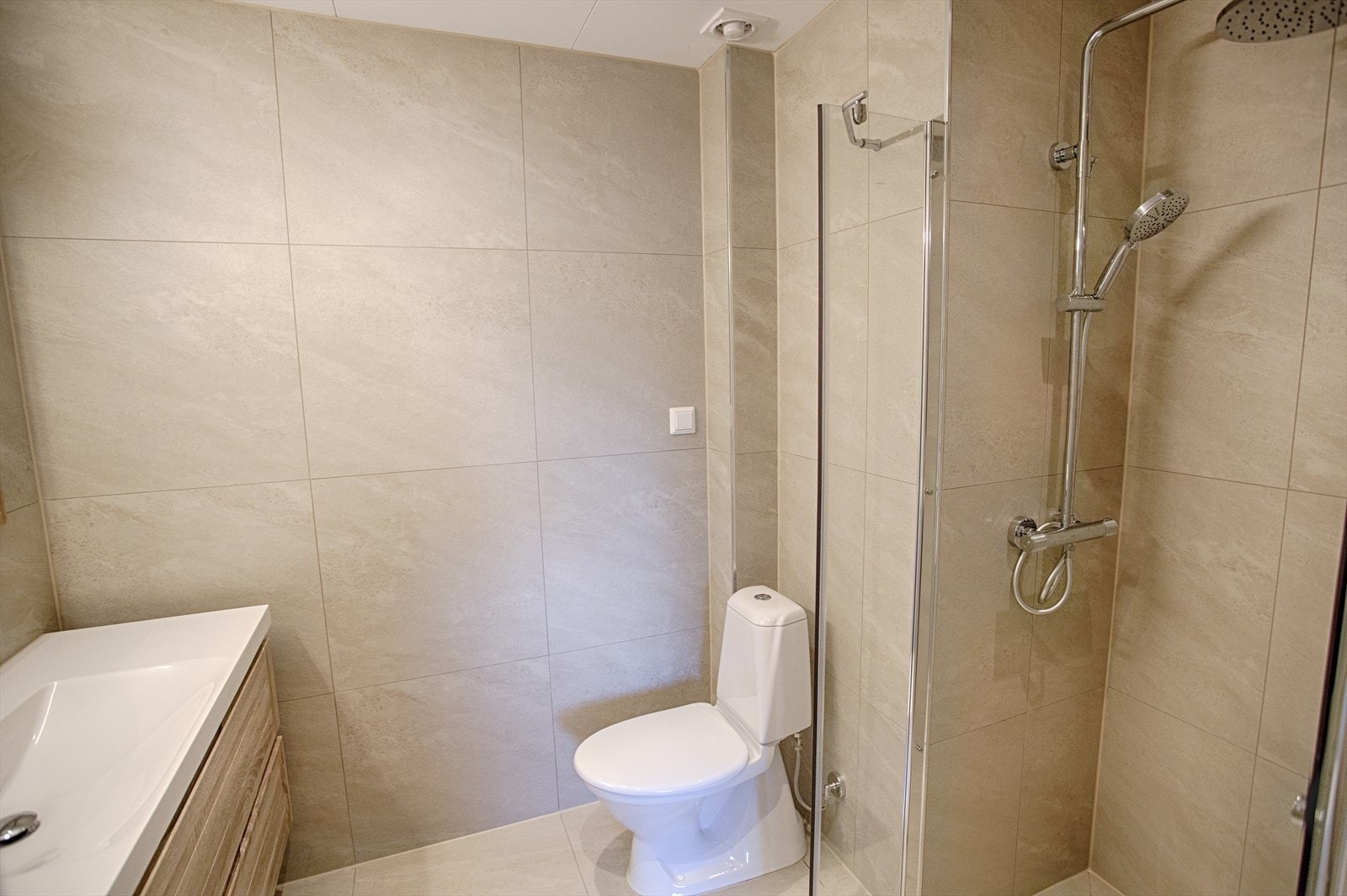 Hele badet har flislagte vegger og en elektrisk avtrekksvifte i himlingen for effektiv ventilasjon. Galleribilde