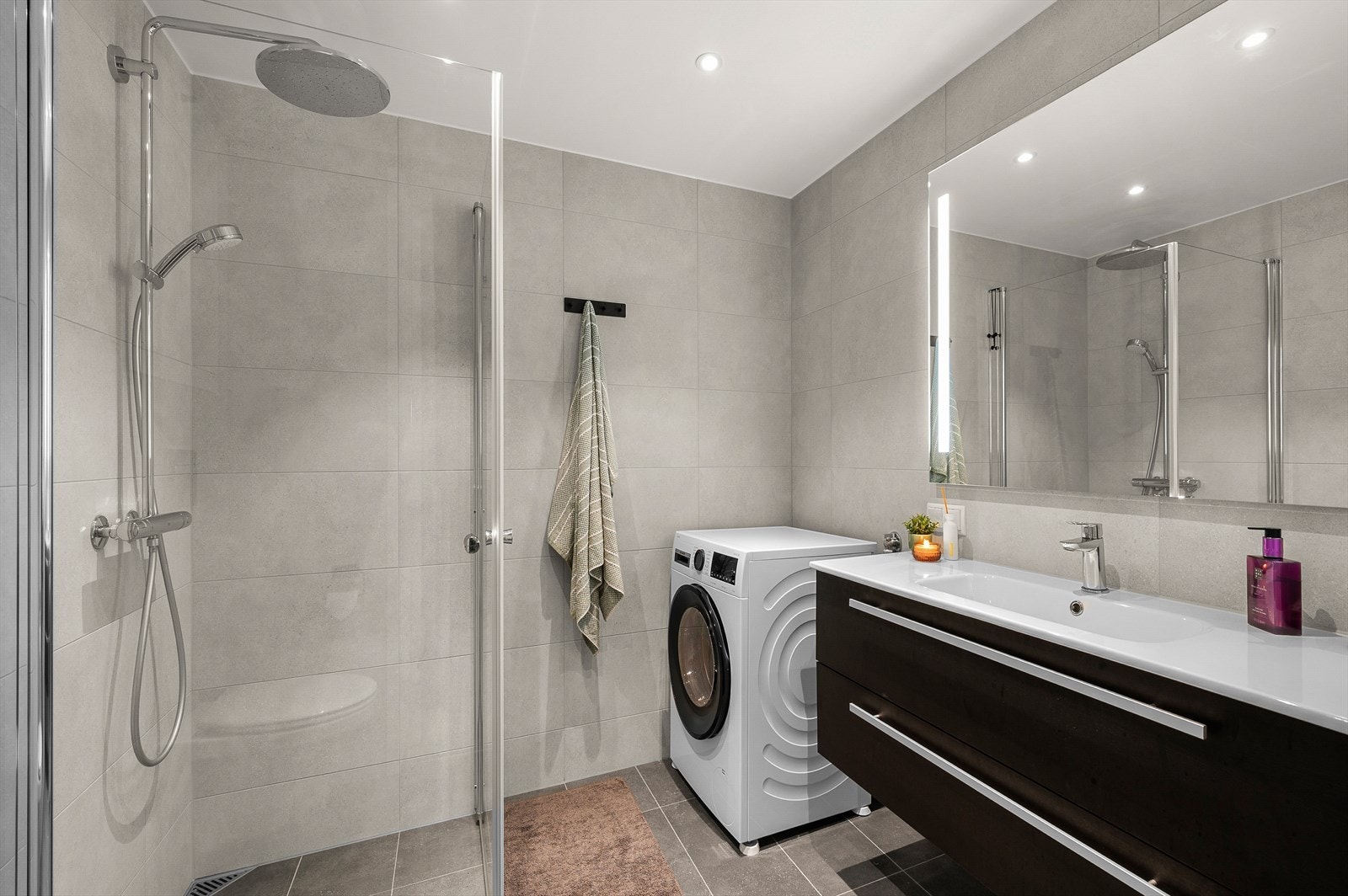 Lyst flislagt bad på hele 4,5 m² med gode oppbevaringsmuligheter og moderne downlights i himling. Galleribilde