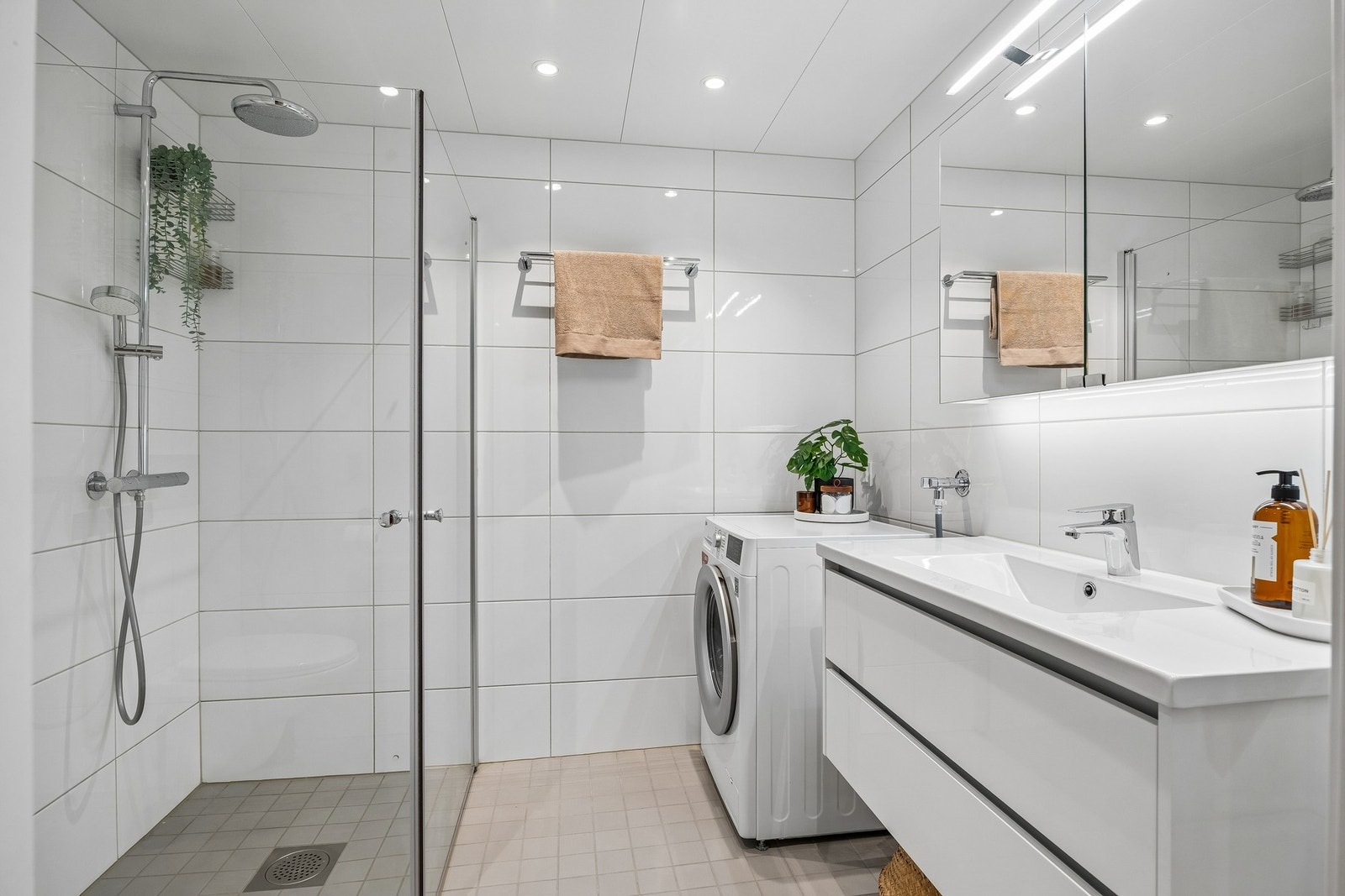 Delikat bad med moderne innredning, dusjløsning og opplegg for vaskemaskin. Galleribilde