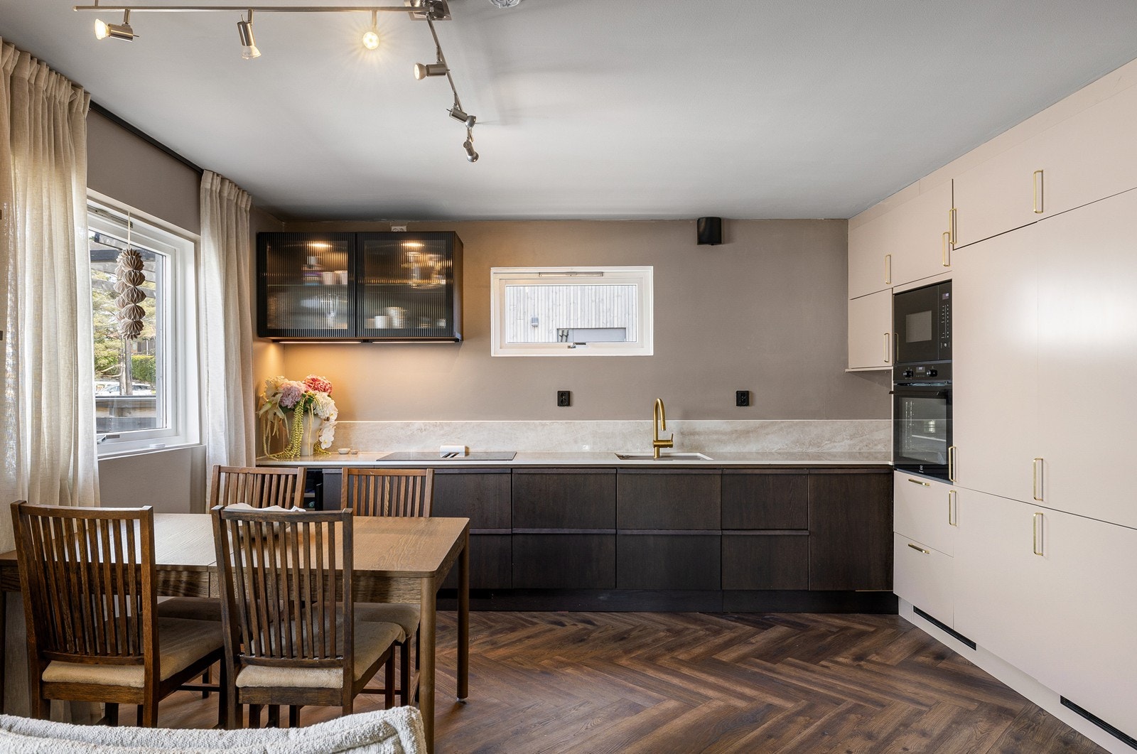 Dette er en drøm for den interiørinteresserte, med en moderne kombinasjon av mørke underskap og sømløse høyskap som sikrer maksimalt med lagringsplass. Galleribilde