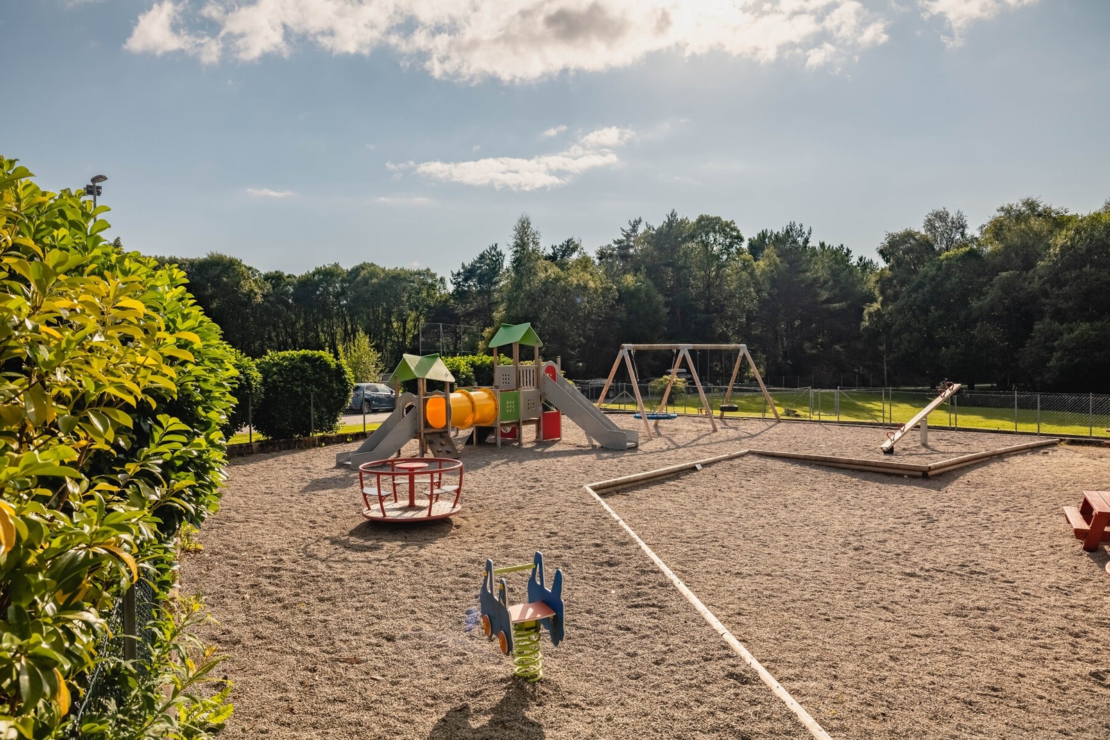 Inngjerdet, solrikt lekeområde med lekeapparater i borettslaget. Galleribilde