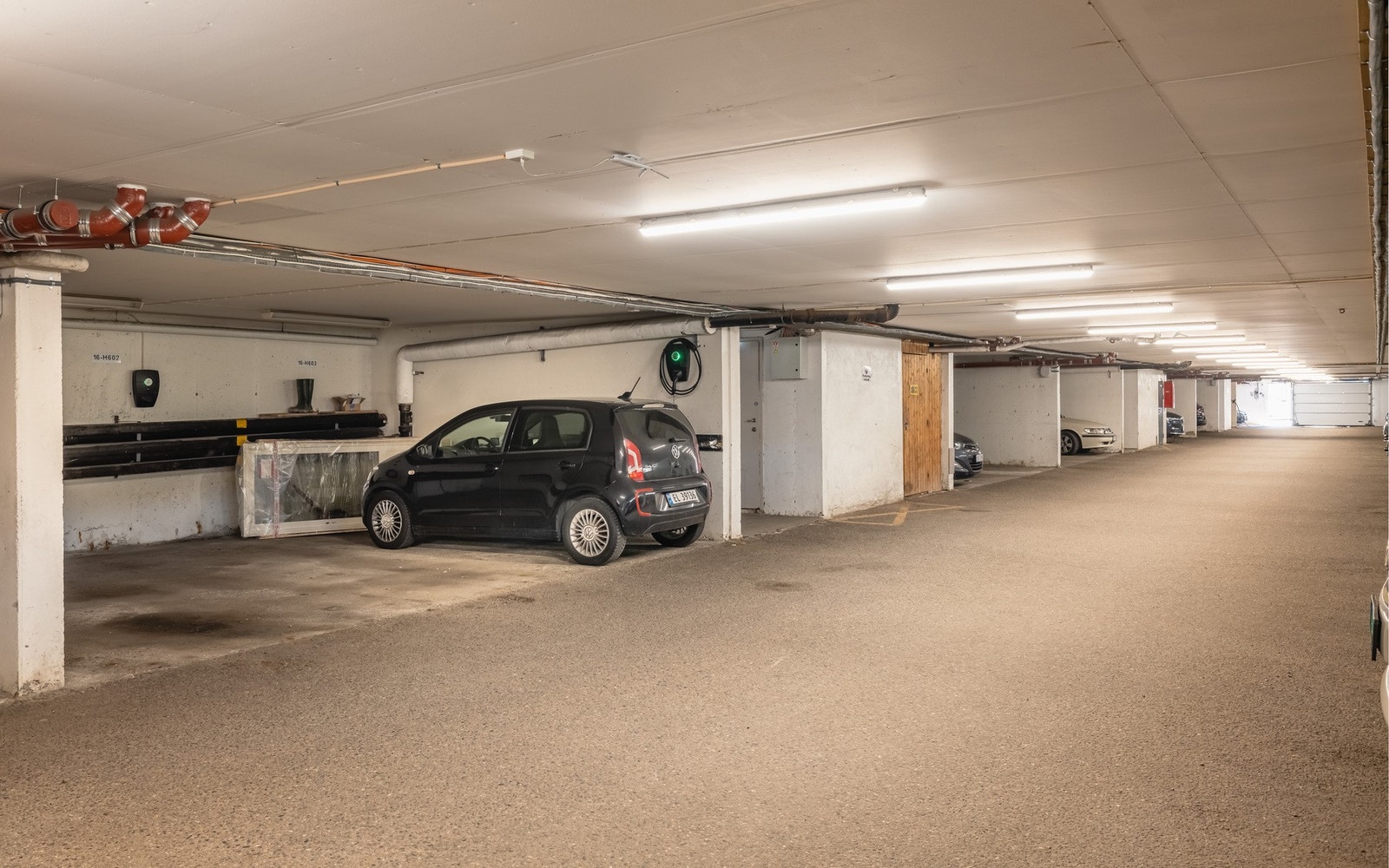 Parkeringsplass i garasje med elbillader medfølger. Galleribilde