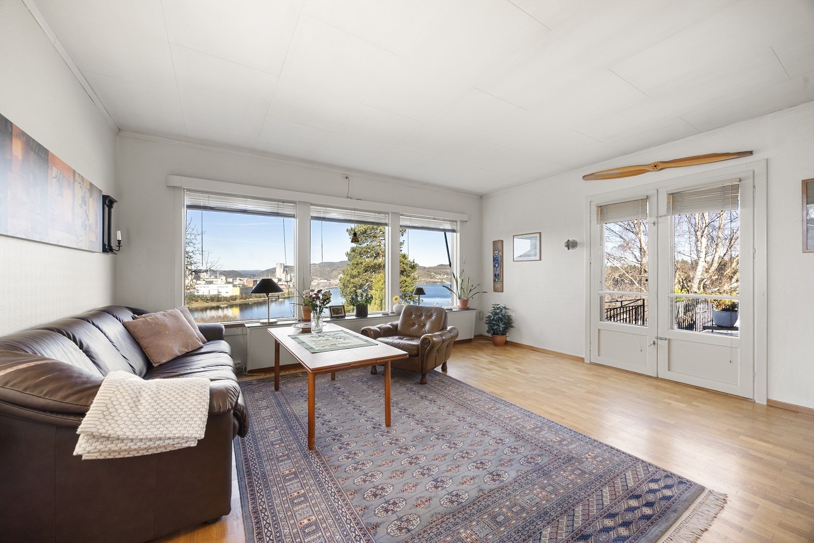 En to-fløyet verandadør åpner ut mot en romslig støpt og flislagt terrasse/platting. Galleribilde