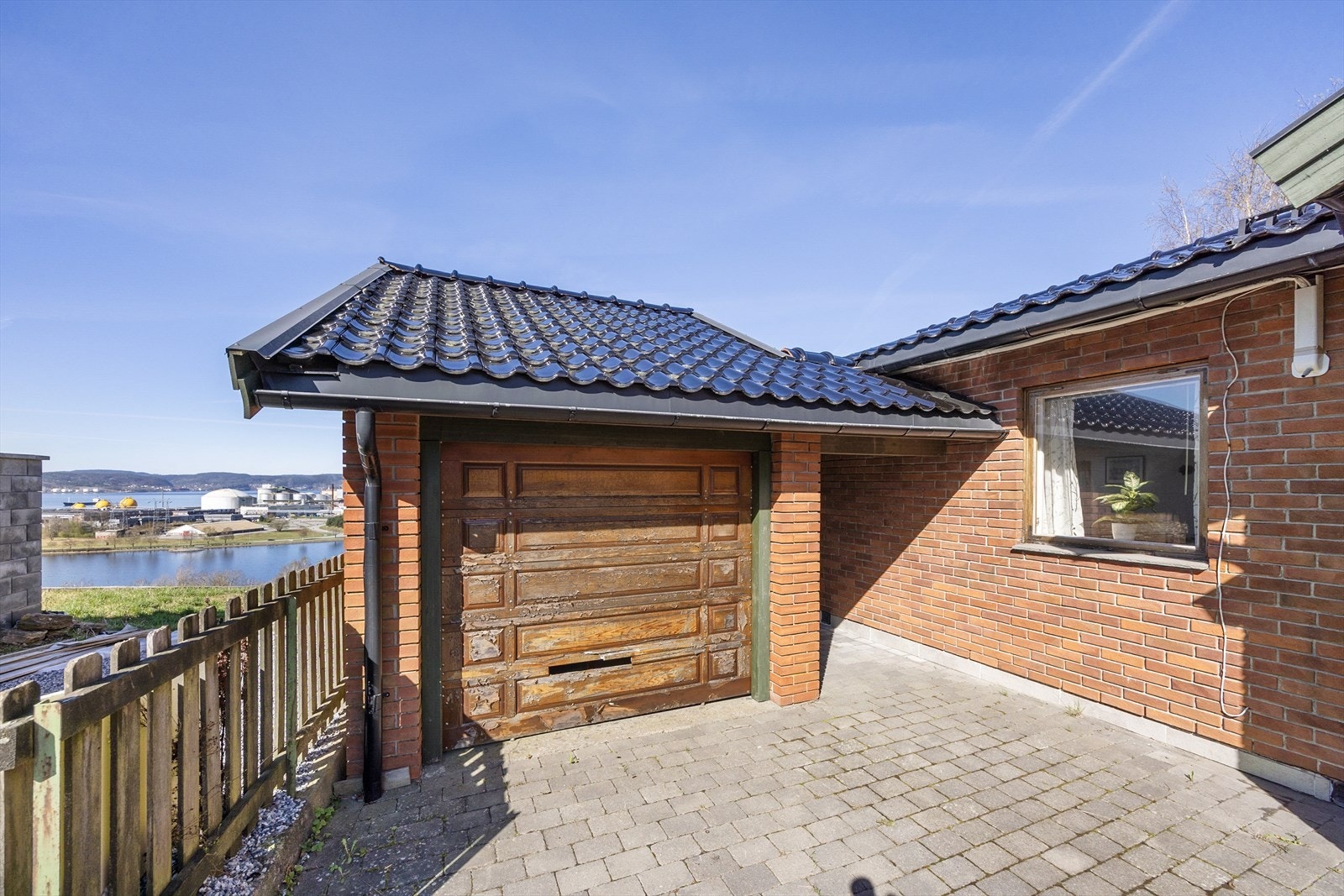 Carporten er bygget i samme stil som huset, og fremstår i dag som en garasje da det er satt inn port i front. Galleribilde