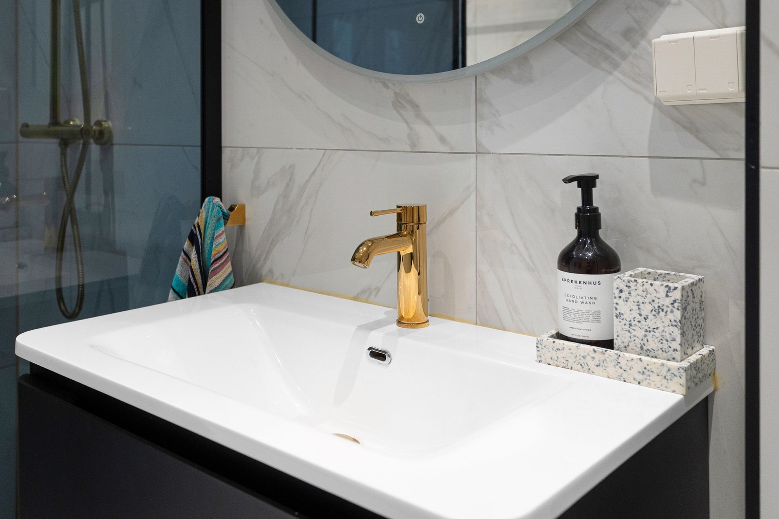 ommet er innredet med vegghengt toalett, servant nedfelt i en mørk skuffeseksjon og et dusjhjørne med svingbare glassdører. Galleribilde