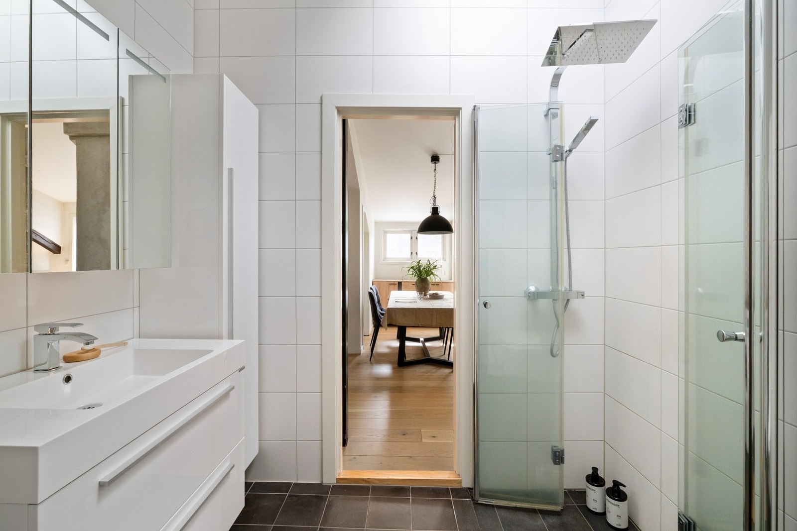 Badet er innredet med vegghengt toalett, servant, speilskap, dusjhjørne med glassvegger, samt opplegg for vaskemaskin. Galleribilde