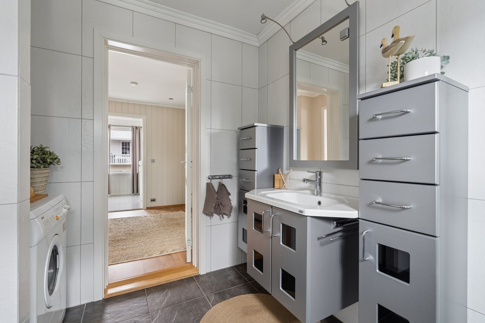 Badet fungerer også som vaskerom, med praktisk plassering av vaskemaskin ved siden av innredningen. Galleribilde
