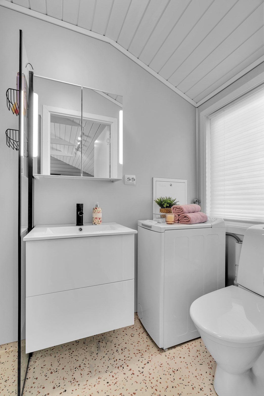 Badet i hovedhytta er utstyrt med servantmøbel, toalett, dusj og opplegg for vaskemaskin. Galleribilde