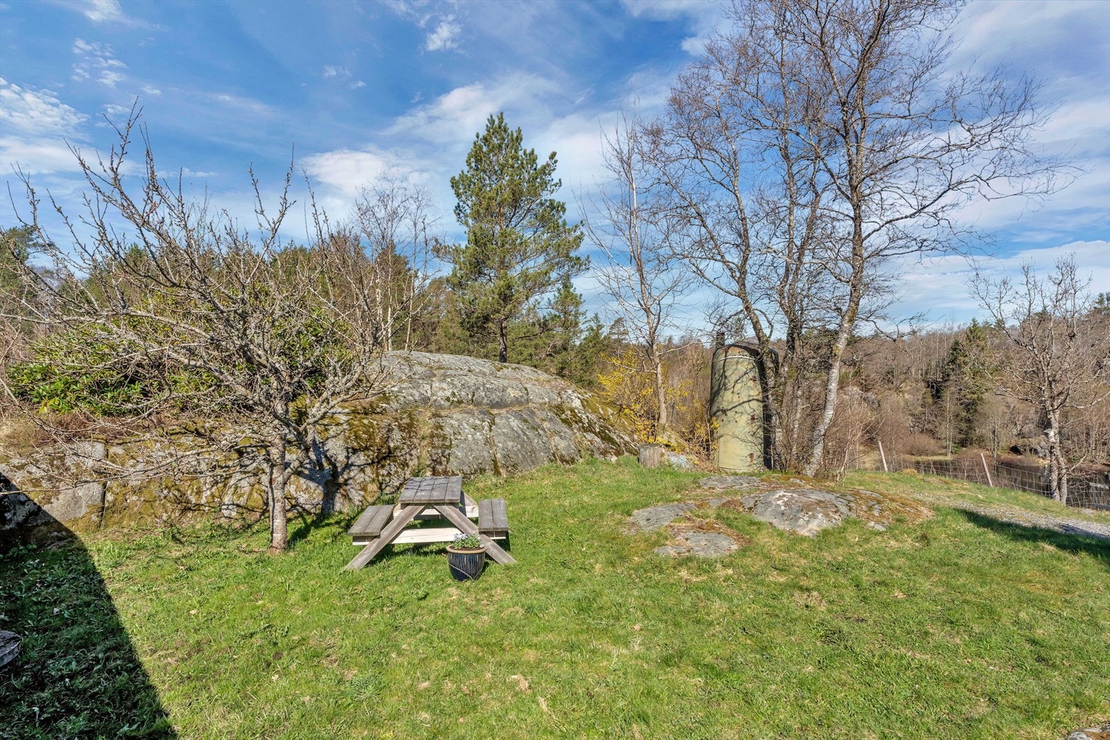 Uteplass med benkebord på naturtomten. Galleribilde