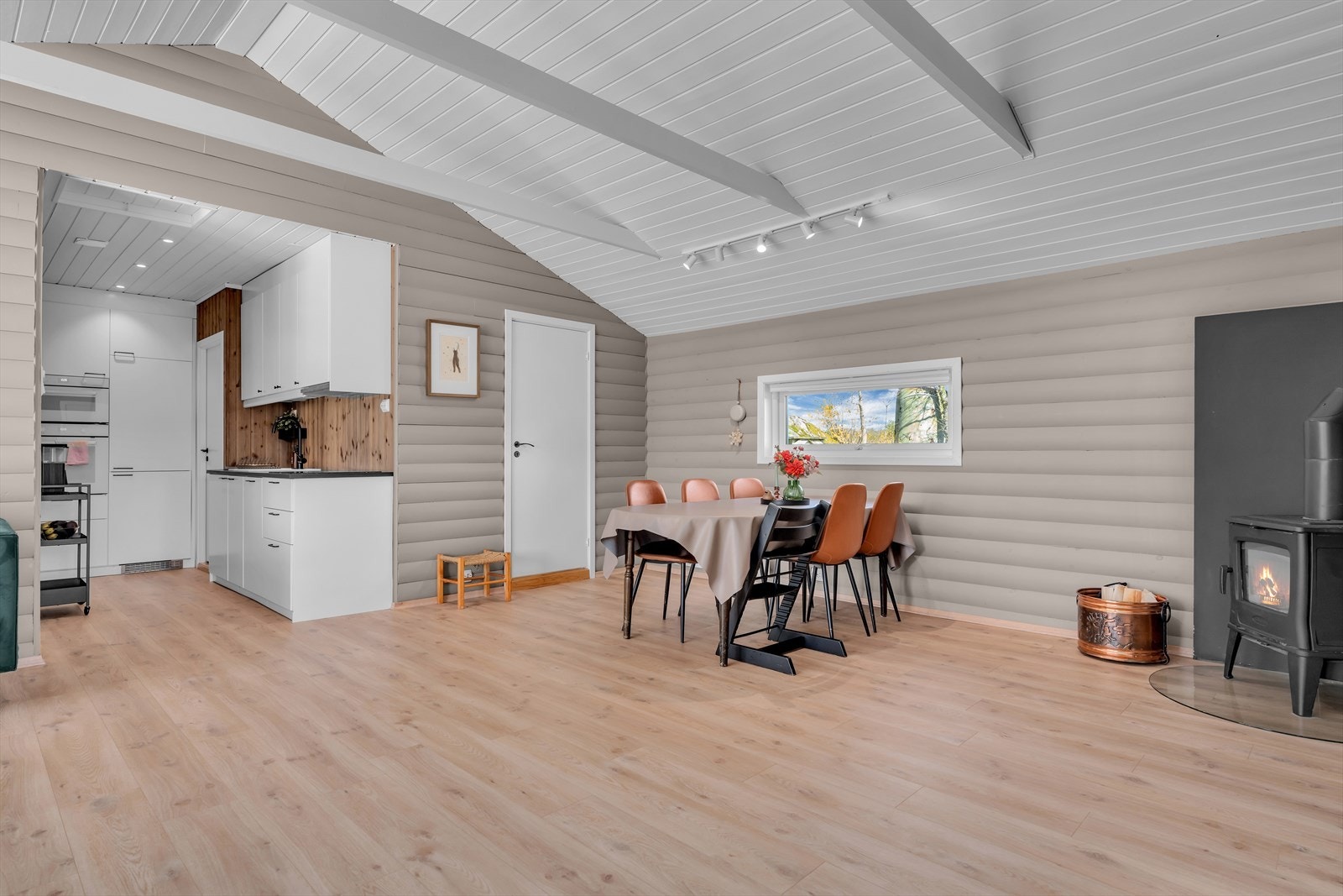 Kjøkkenet er praktisk plassert i åpen løsning med stuen, og vedovnen sørger for varme og hygge. Galleribilde