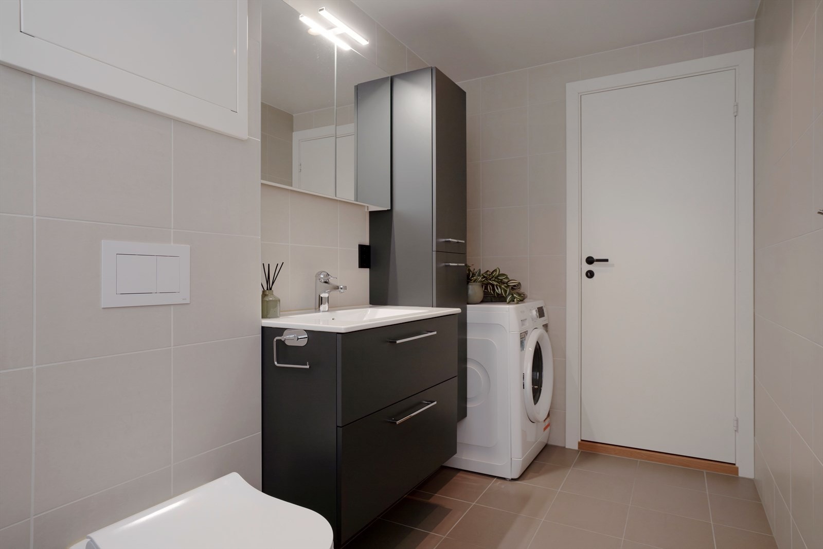 Badet er innredet med dusjhjørne, servant med innredning, speilskap og høyskap, samt vegghengt toalett. Opplegg for vask og tørk på badet. Galleribilde