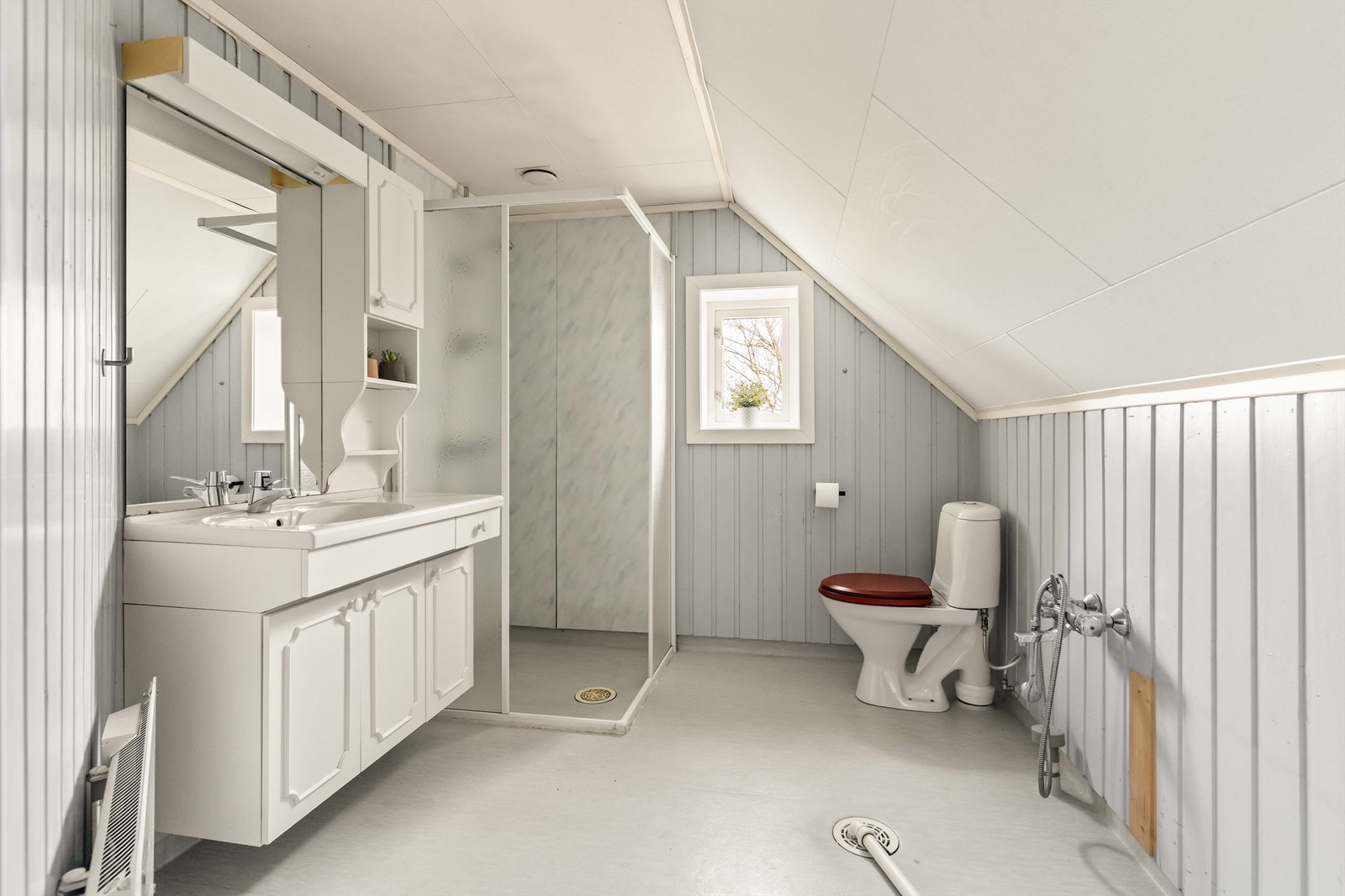 Boligens baderom befinner seg i 2. etg. og inneholder servantinnredning, dusjhjørne, toalett og opplegg for vaskemaskin. Galleribilde