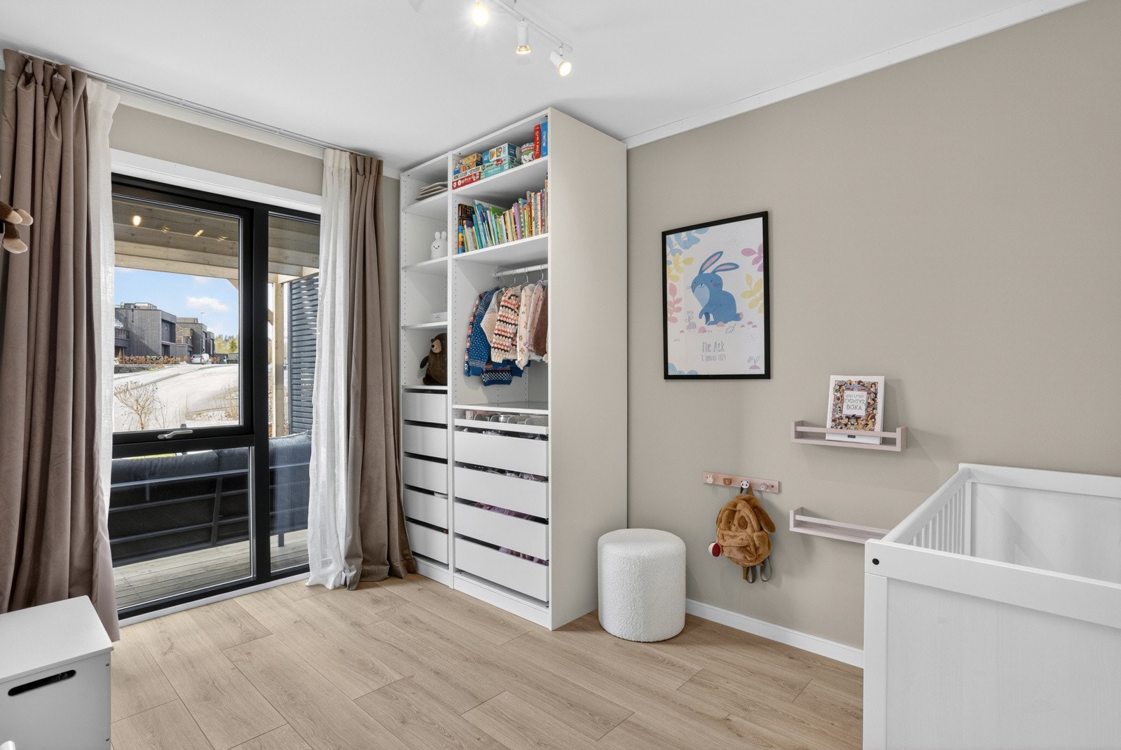 Et av soverommene i første etasje har en god og funksjonell størrelse, med plass til både seng og garderobeløsning. Et stort vindusparti sørger for rikelig med naturlig lys og gir rommet en lys og trivelig atmosfære. Galleribilde