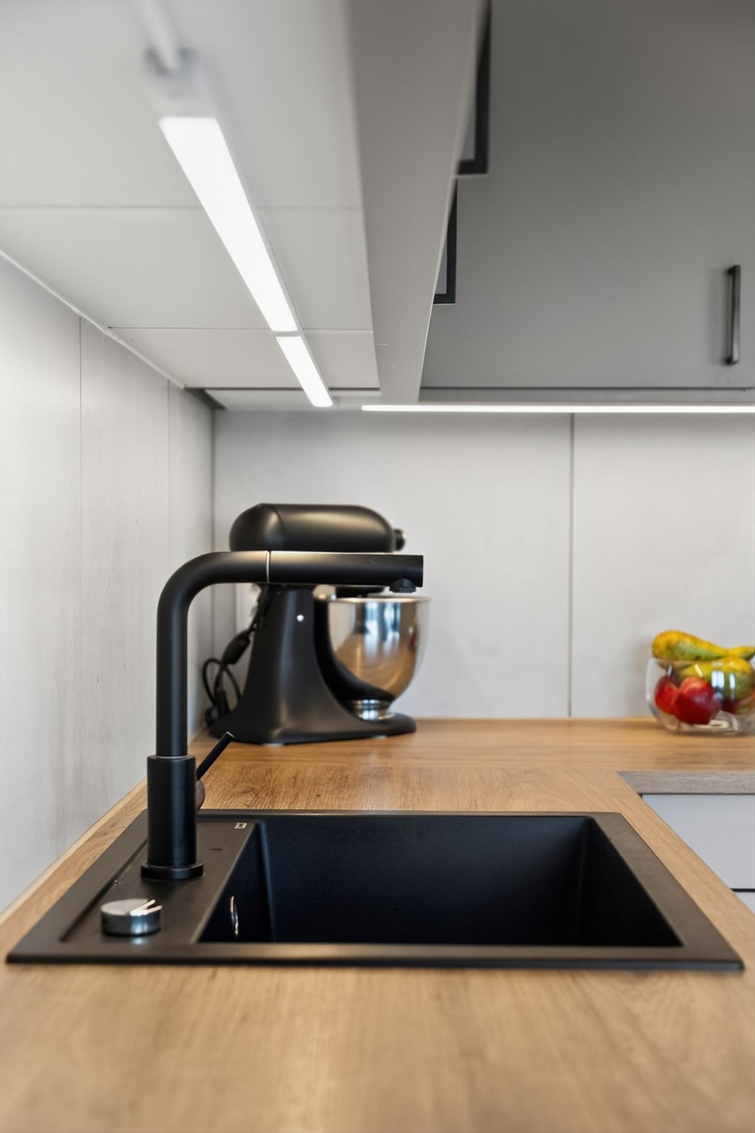 Kjøkkenet har en praktisk kum i komposittmateriale kombinert med et moderne, sort armatur som gir et stilrent uttrykk. Galleribilde