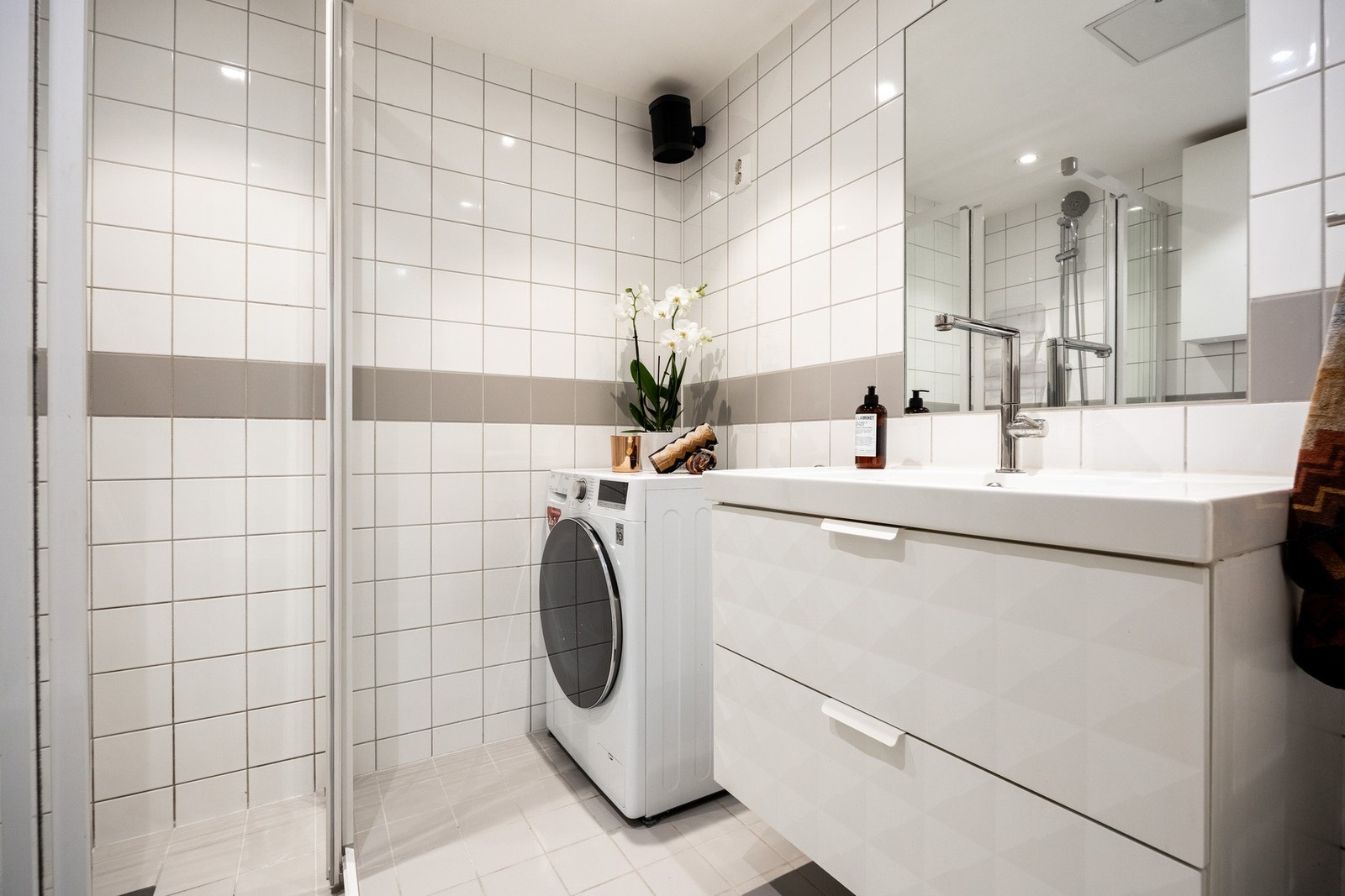Badet er innredet med vegghengt servantinnredning med skuffer, innfelt speil med stikkontakt. dusjhjørne med skyvedører av glass og dusjarmatur tilkoblet veggmontert hånddusj, samt gulvstående toalett. Galleribilde