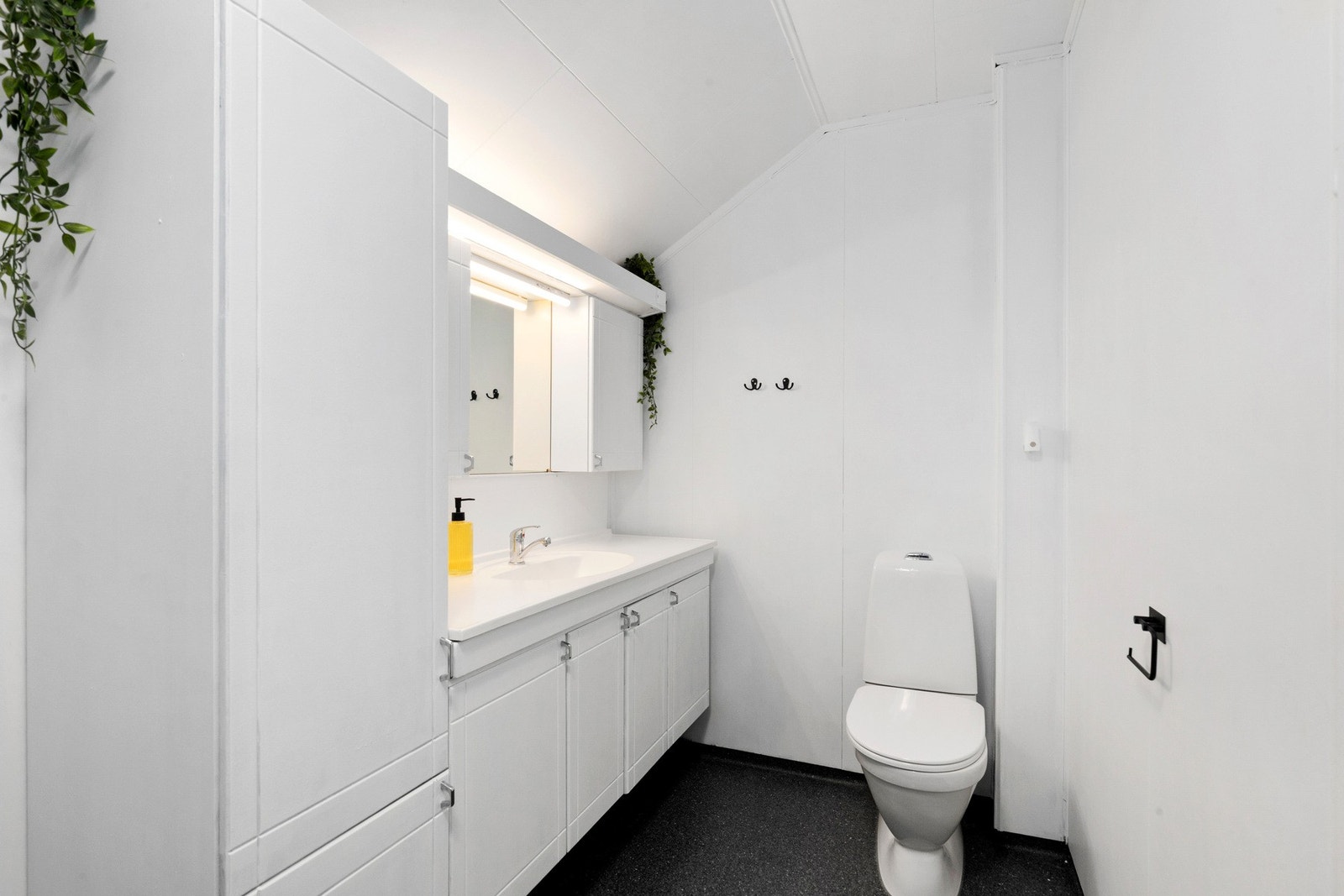 Bad på 6,3 kvm. bestående av dusjkabinett, gulvmontert toalett, innredning med servant, opplegg for vaskemaskin. Galleribilde