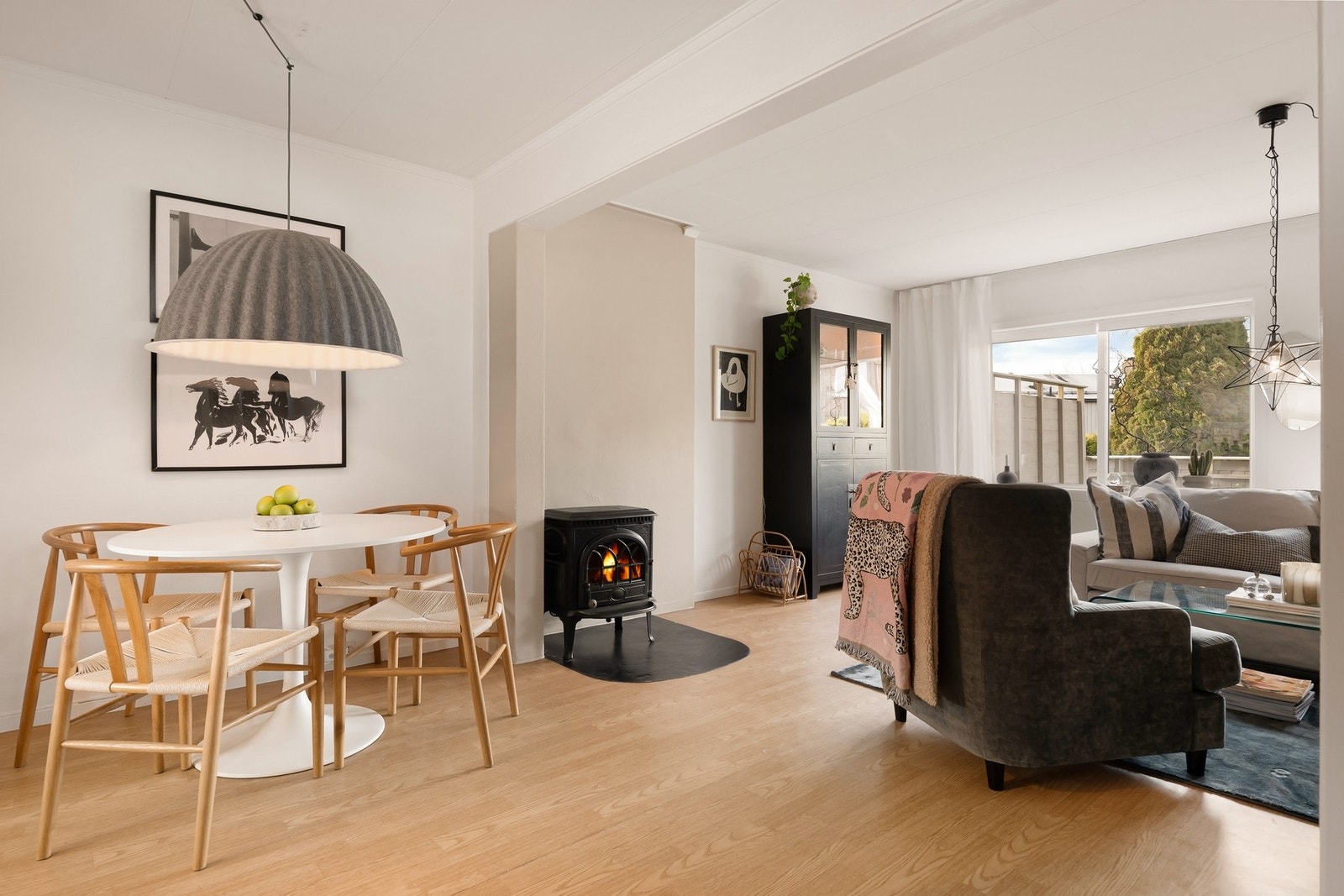 Lun stue med peis og store vindusflater som slipper inn dagslys Galleribilde