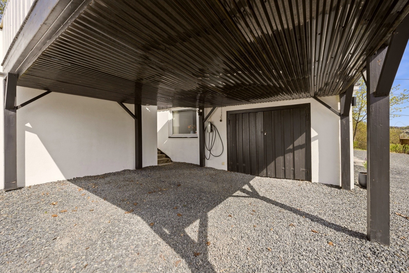 Eiendommen har gode parkeringsmuligheter med carport, garasjebod, oppstillingsplass og elbillader. Galleribilde