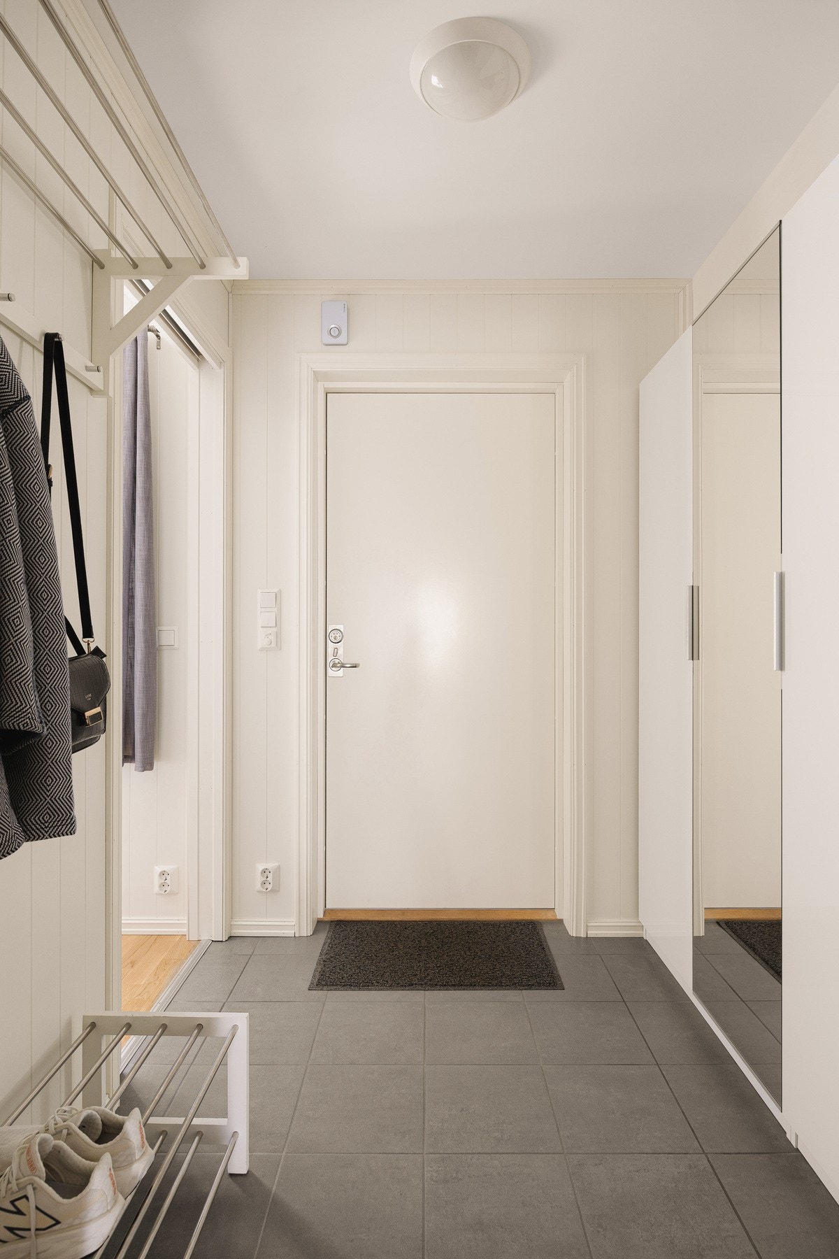 Veggene er kledd med lysmalte panelplater som gir en lun og hjemmekoselig følelse, og det er god plass til garderobeløsning, kommode eller annen oppbevaring. Galleribilde