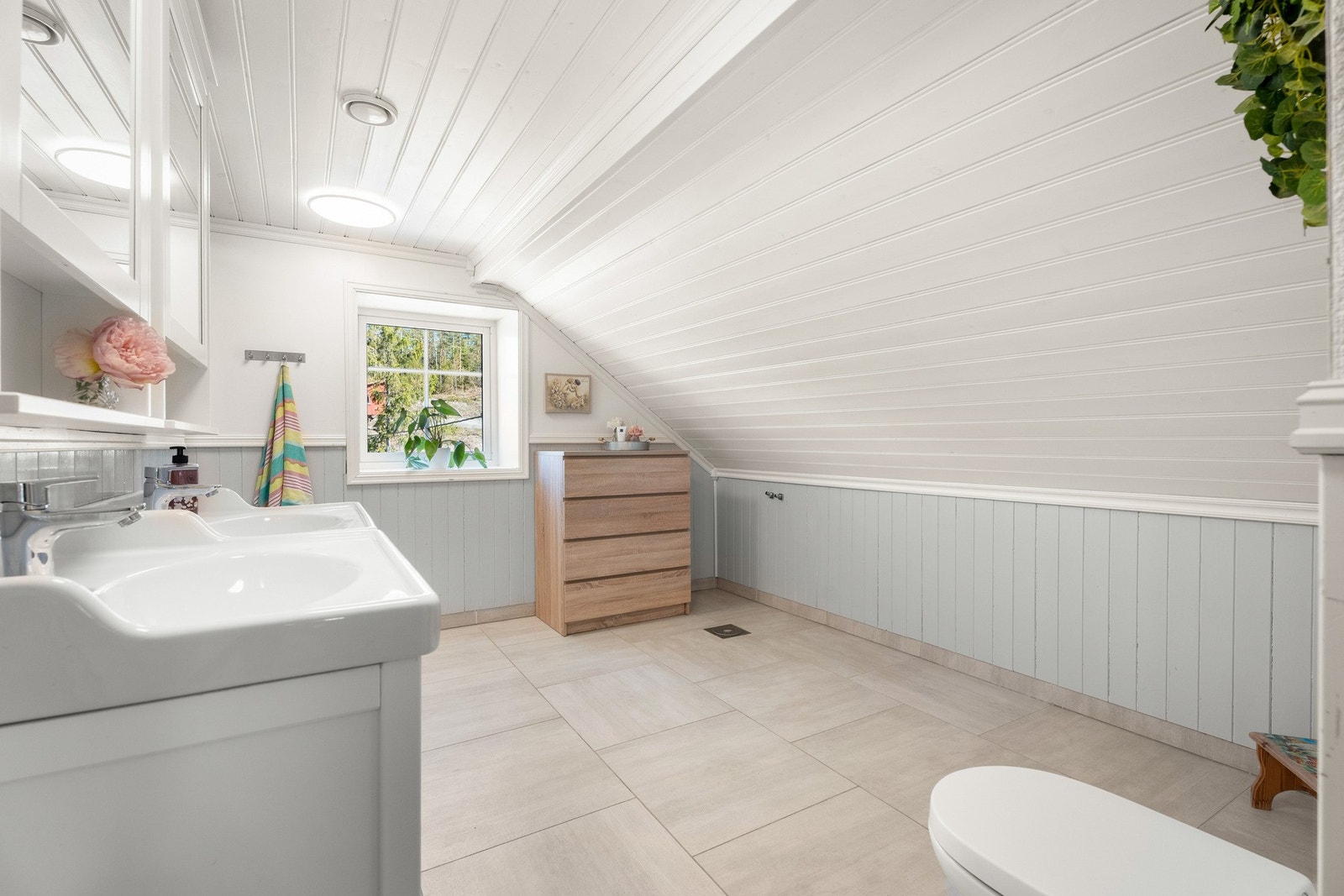 Badet er romslig og funksjonelt, med fliser på gulv og praktiske overflater. Galleribilde