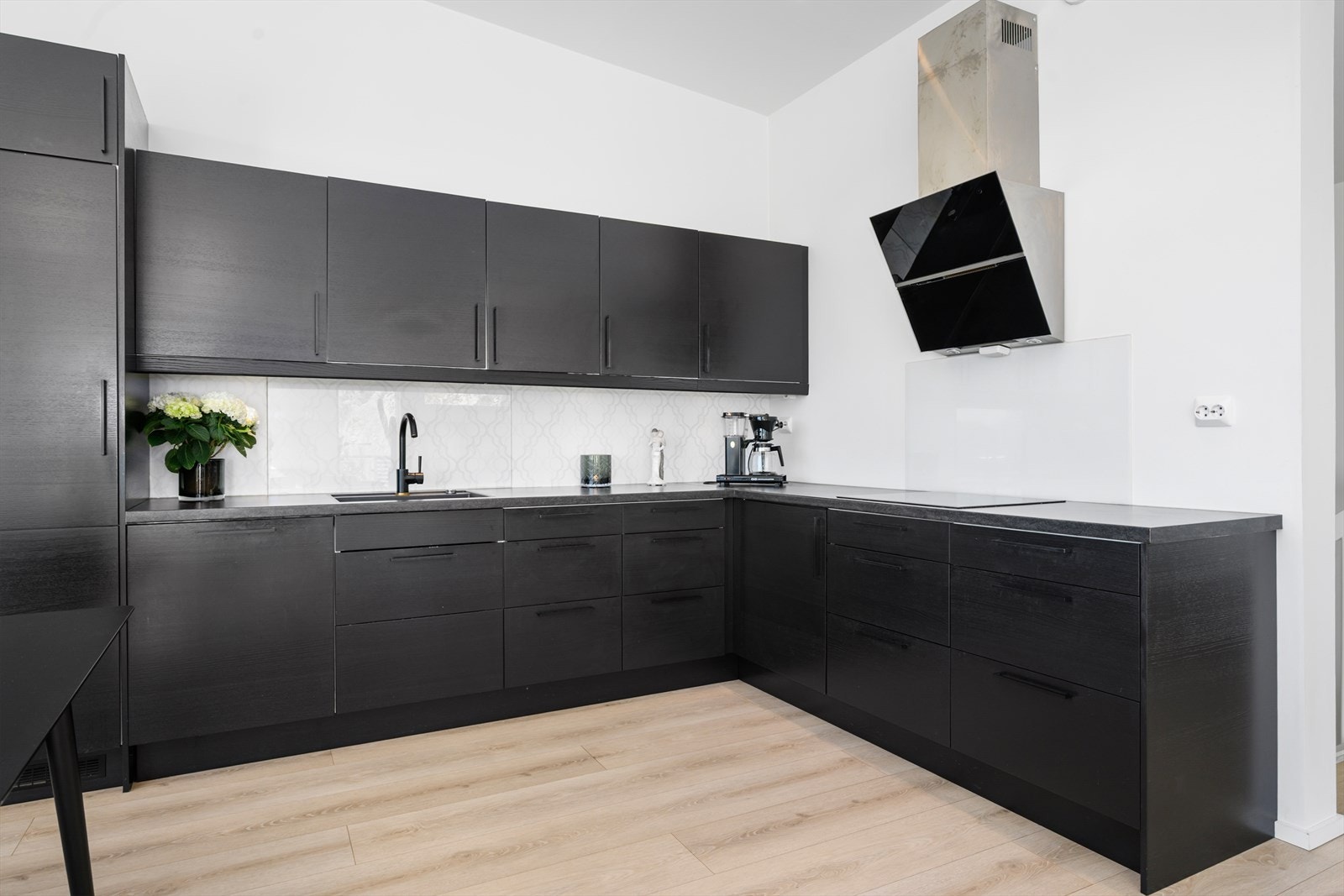 Kjøkkeninnredningen har slette, mørke fronter og laminatbenkeplate. Alle hvitevarer er integrert, inkludert stekeovn, mikrobølgeovn, koketopp og oppvaskmaskin. Galleribilde