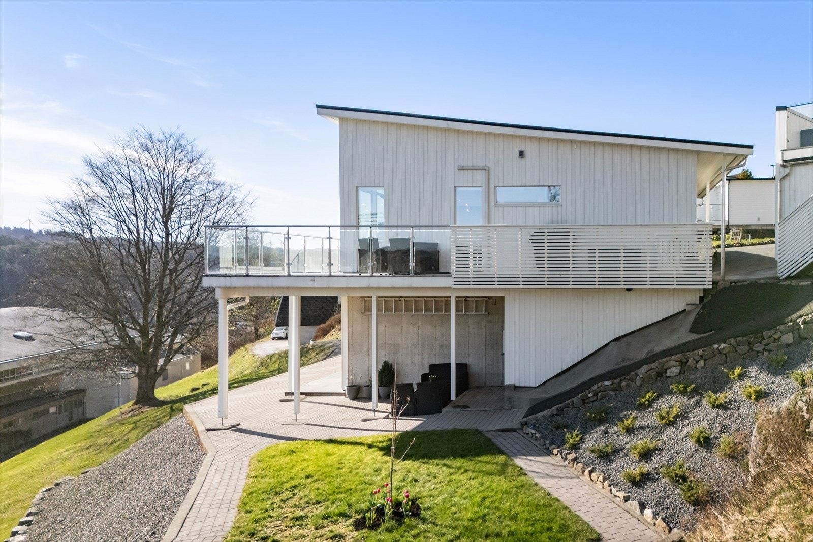 Lettstelt og pent opparbeidet uteområde med belegningsstein og plen. Galleribilde