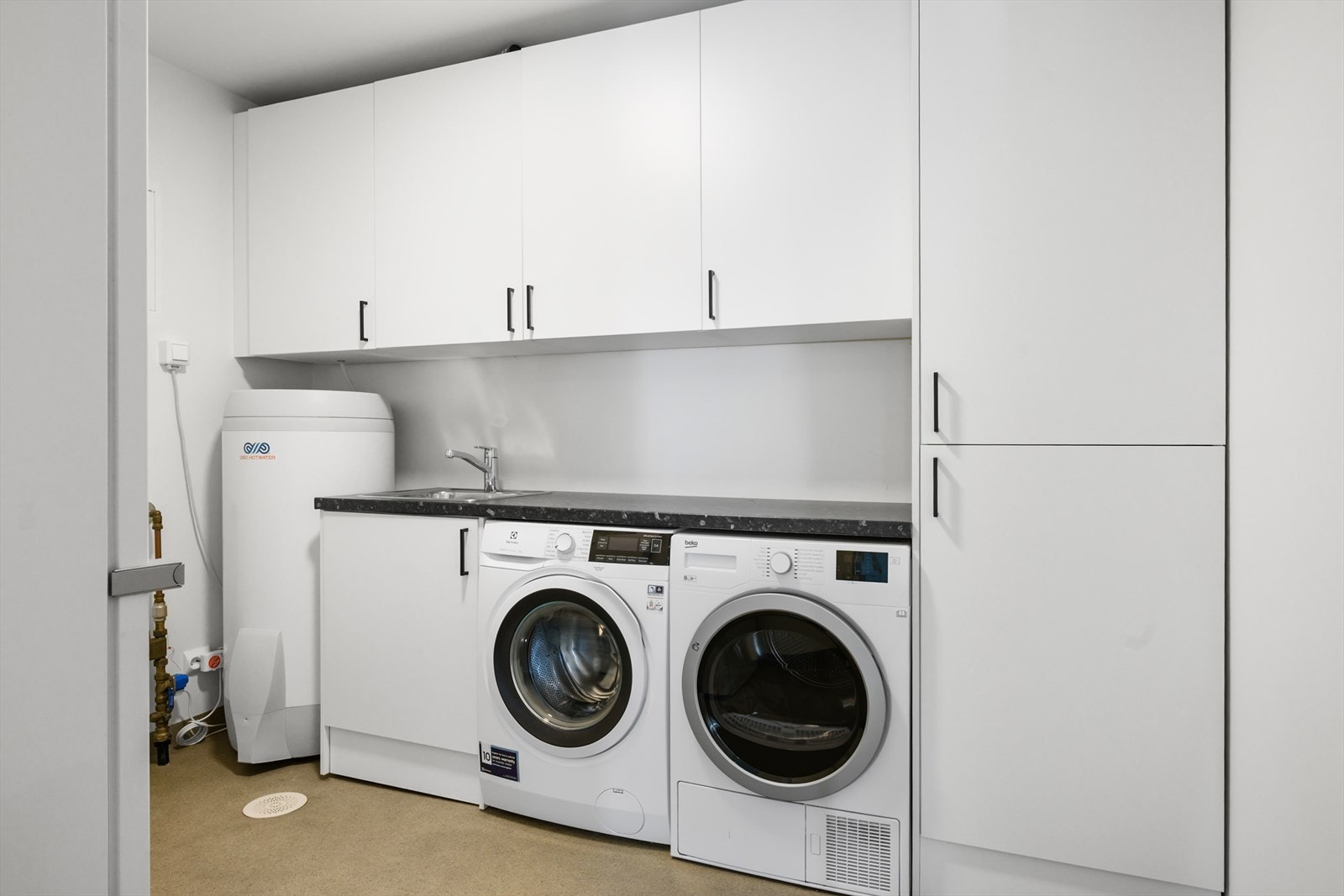 Separat vaskerom med vinylbelegg og varmekabler. Her er det opplegg for vaskemaskin og tørketrommel, samt plassering av varmtvannstank og ventilasjonsaggregat. Galleribilde