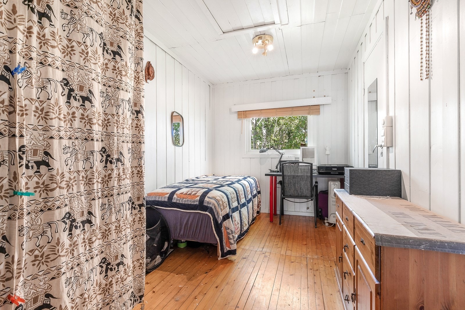 Det første soverommet har gulvbord og malt panel på vegger, og tilbyr plass til en dobbeltseng. Galleribilde