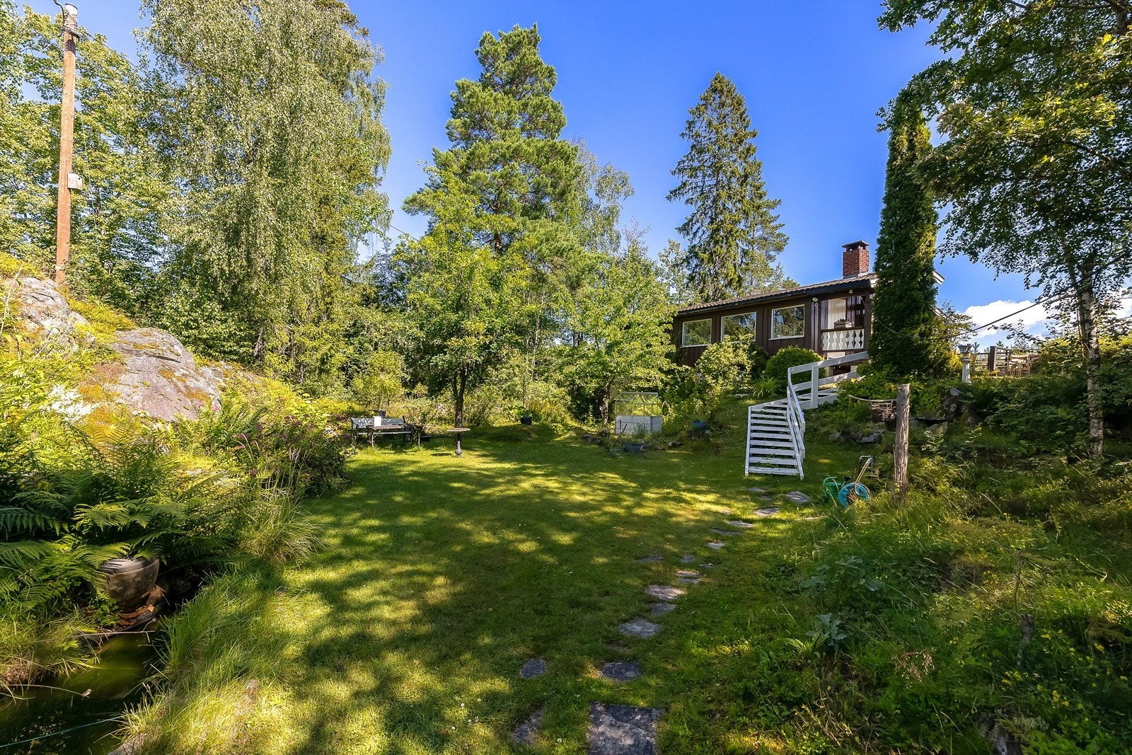 Eiendommen har en stor og usjenert naturtomt med pent opparbeidede uteplasser, ideelt for rekreasjon og fritid. Galleribilde
