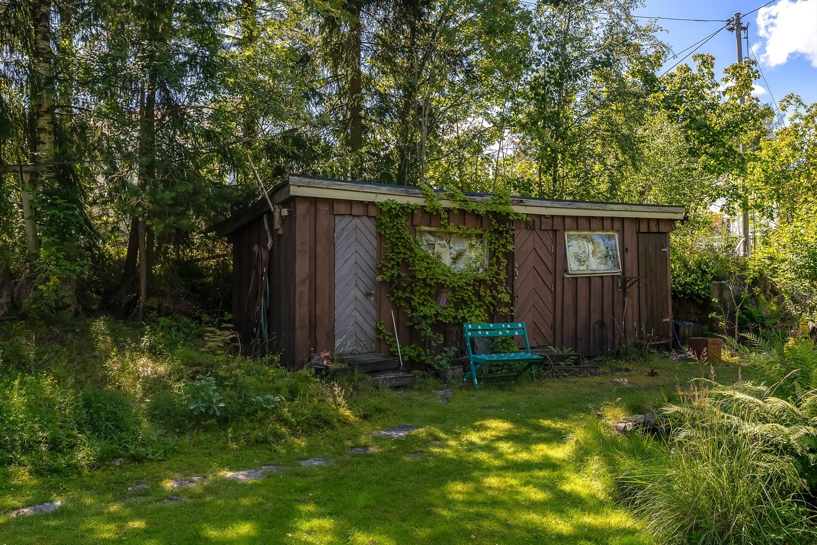 Et praktisk uthus på tomten gir god lagringsplass for hageredskaper og annet utstyr. Galleribilde