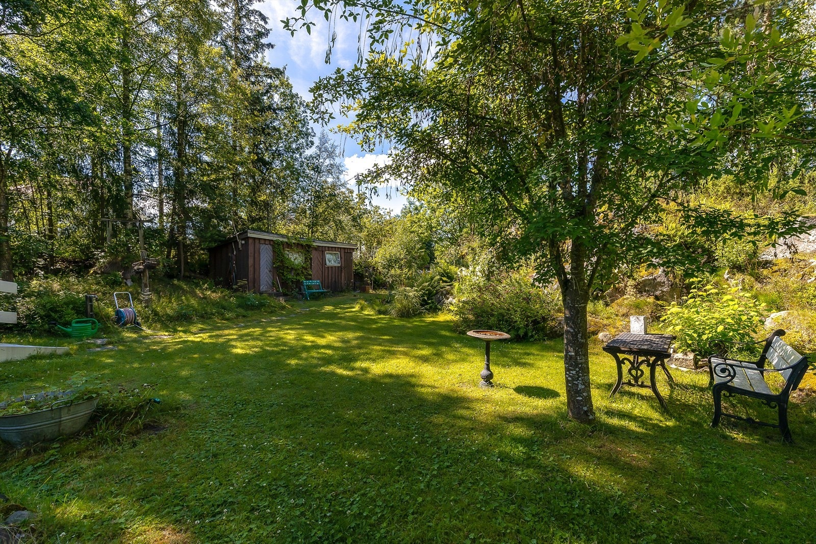 Den store tomten byr på en frodig plen og naturskjønne omgivelser, perfekt for lek og avslapning utendørs. Galleribilde