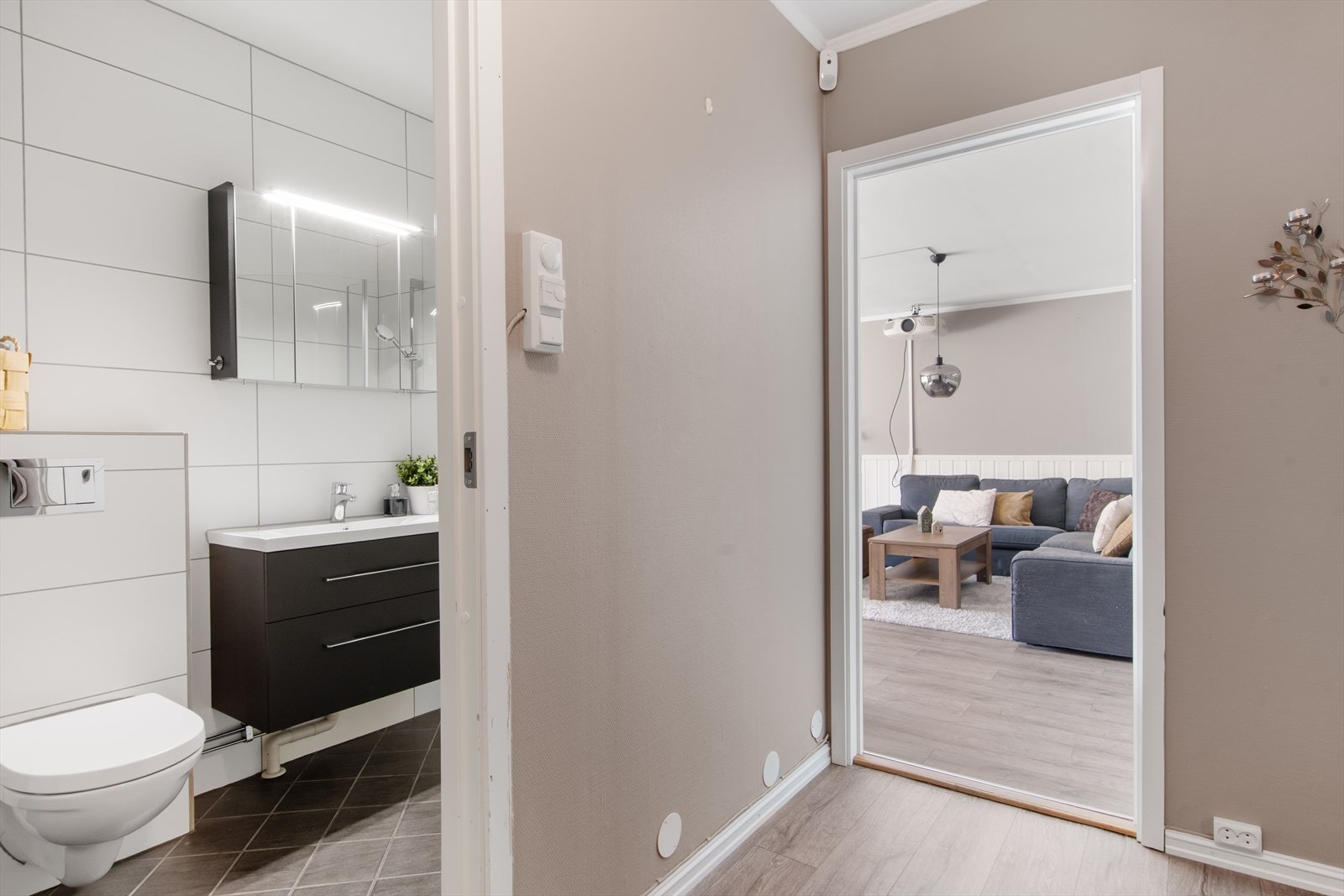 Fra gangen er det inngang til badet og inn i stuen. Alle rommene er malt i gjennomgående fargetoner noe som skaper en god harmoni i leiligheten. Galleribilde