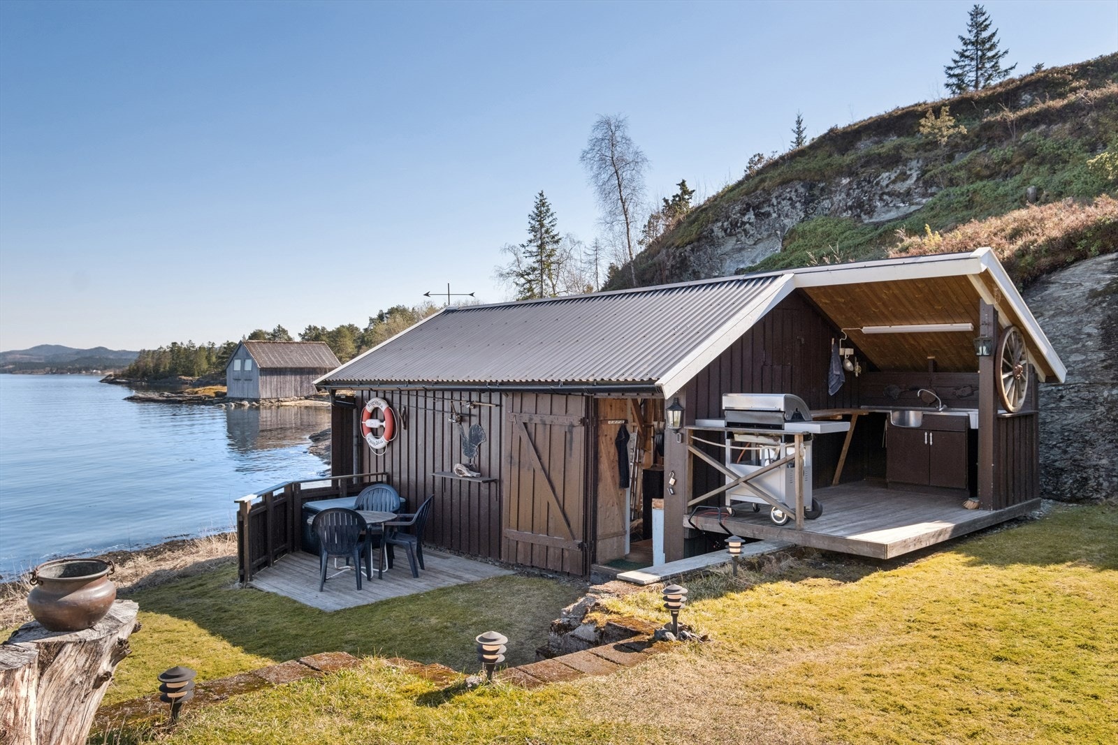 Naustet byr på god lagringsplass og et praktisk utekjøkken, perfekt for å tilberede dagens fangst. Galleribilde