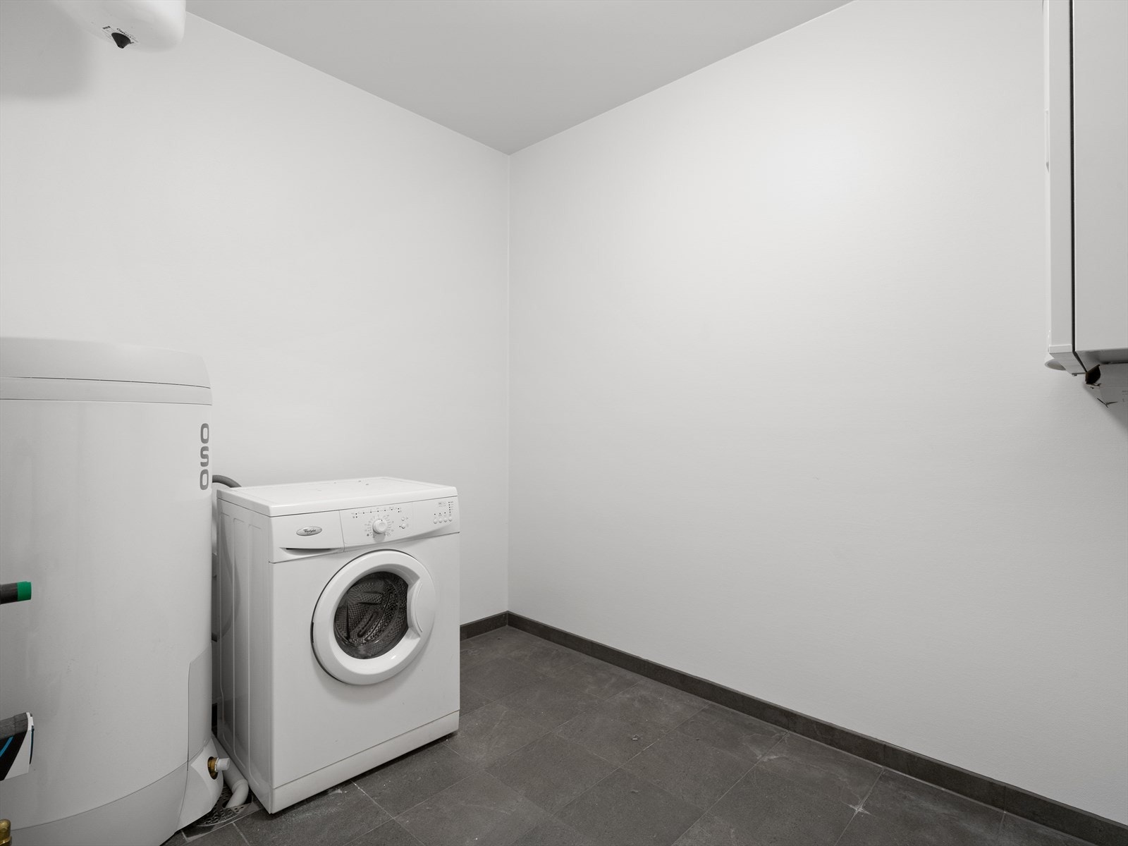 Praktisk, separat vaskerom med flislagt gulv med varmekabler. Her er også boligens tekniske installasjoner samlet. Galleribilde