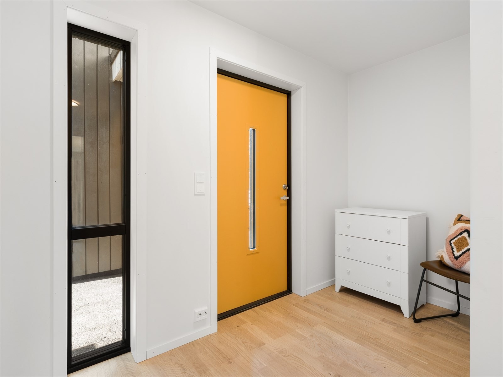Inngangspartiet er lyst og innbydende, med parkett på gulvet som er gjennomgående i store deler av boligen. Galleribilde