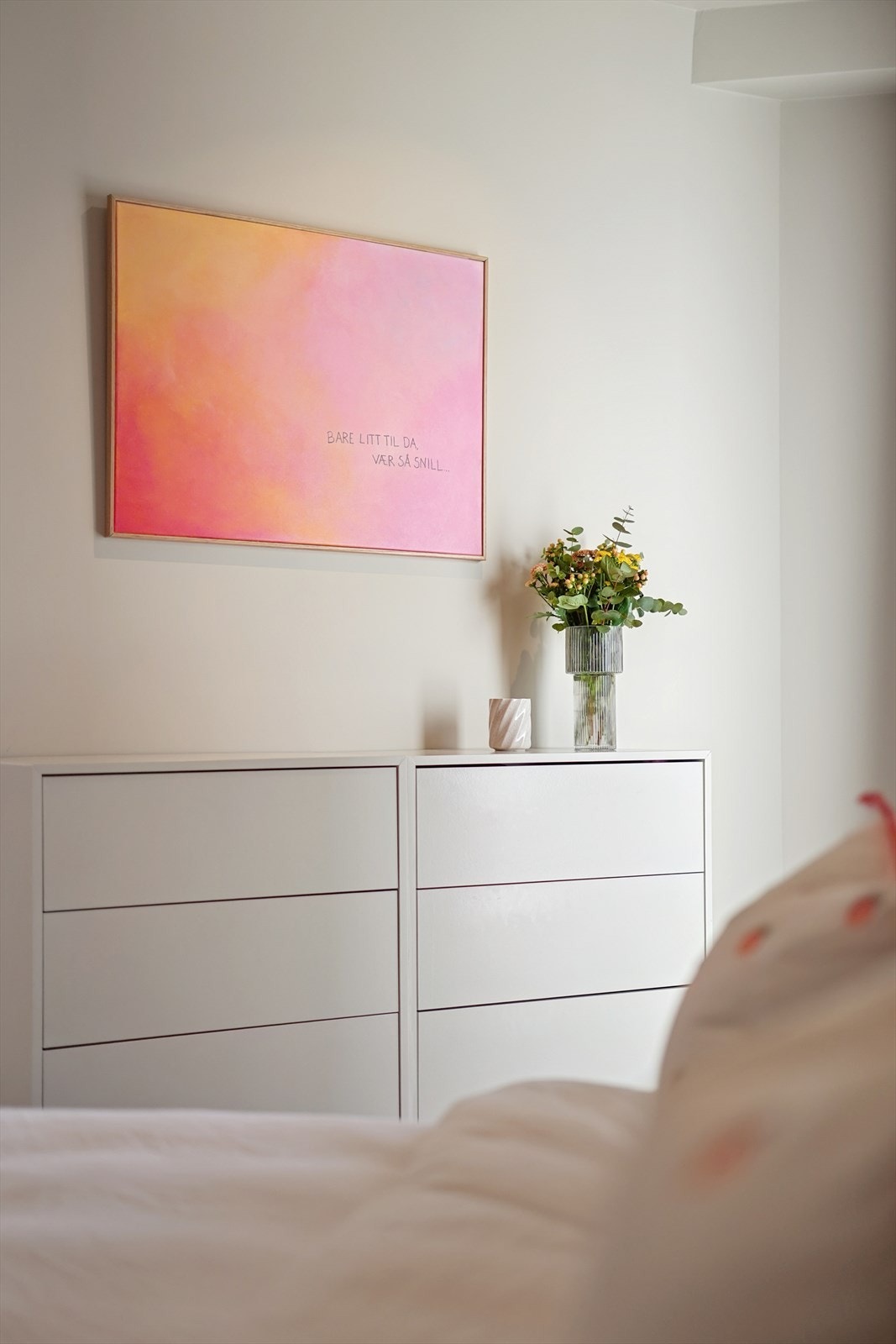 Her er det rom for personlig innredning, med en stilren kommode som komplementerer rommets palett. Galleribilde