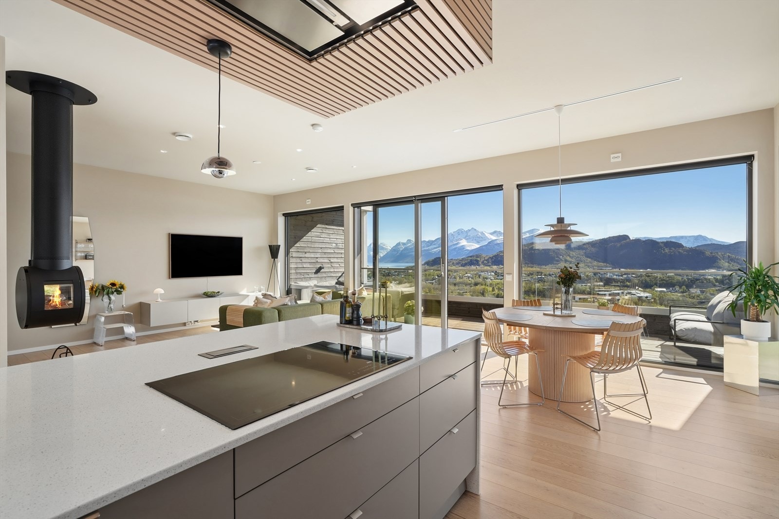 Kjøkkenet fra Sigdal, installert i 2023, er utstyrt med glatte takhøye fronter og en stor øy med Silestone kvartskompositt benkeplate. Galleribilde