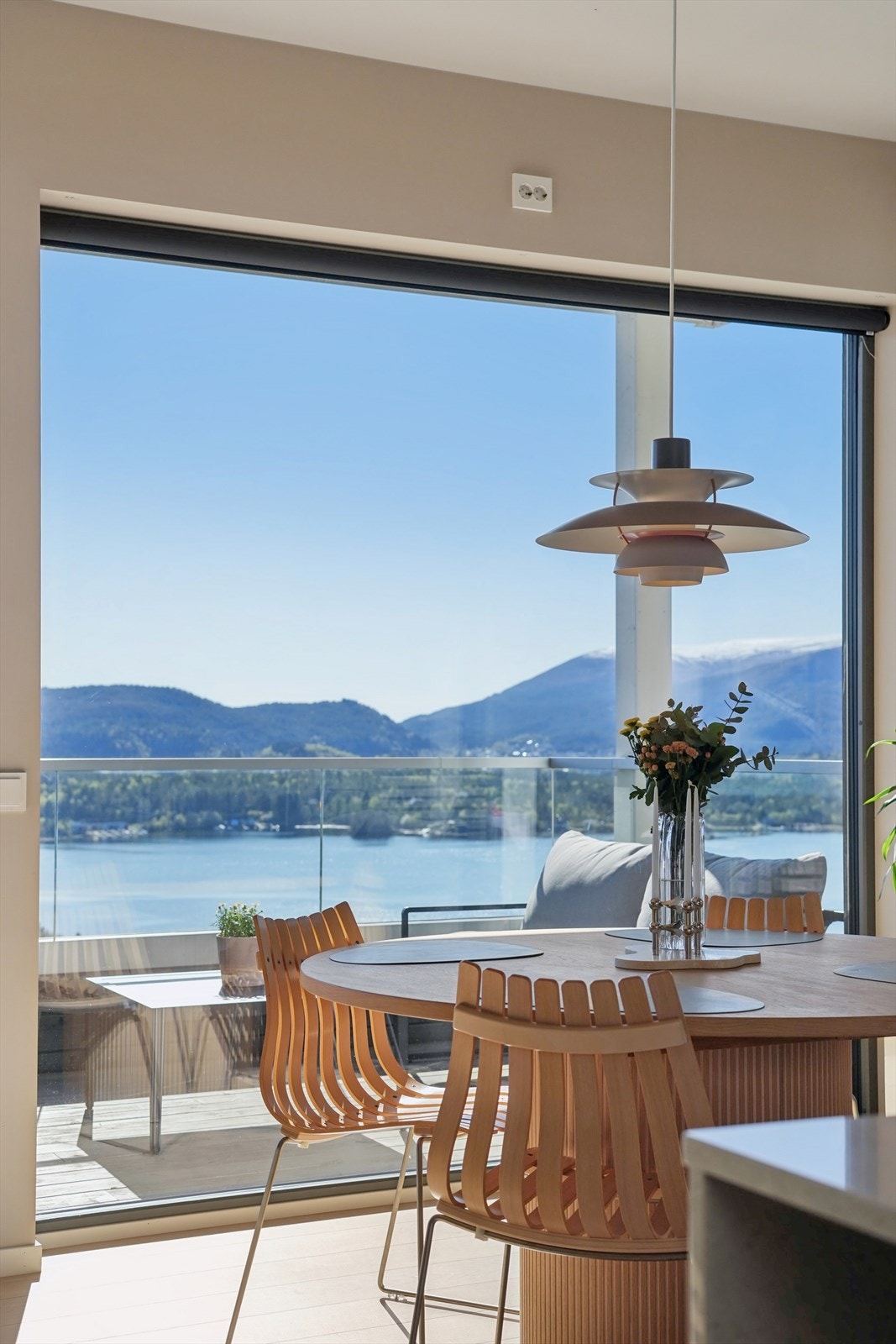 Utsikten smelter inn i stuen med vinduer som går helt ned til gulvet. Galleribilde