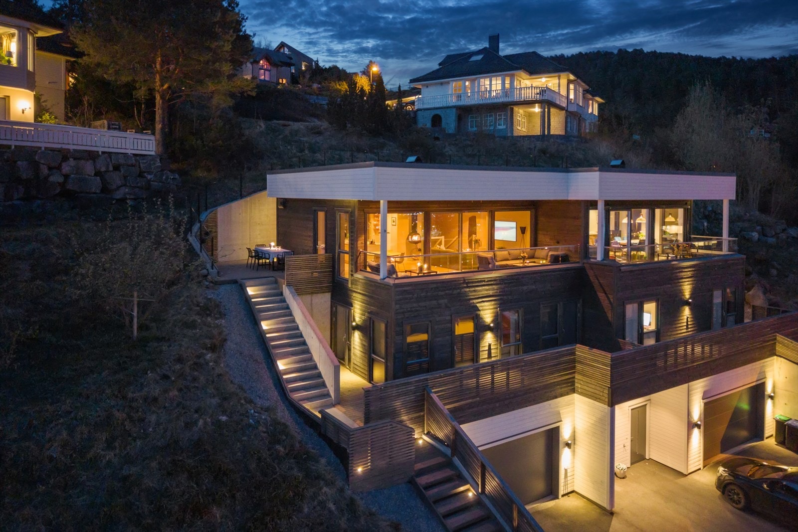 Denne vertikaldelte tomannsboligen fra 2023 presenterer en moderne arkitektur med en imponerende utsikt over fjell og fjord. Galleribilde