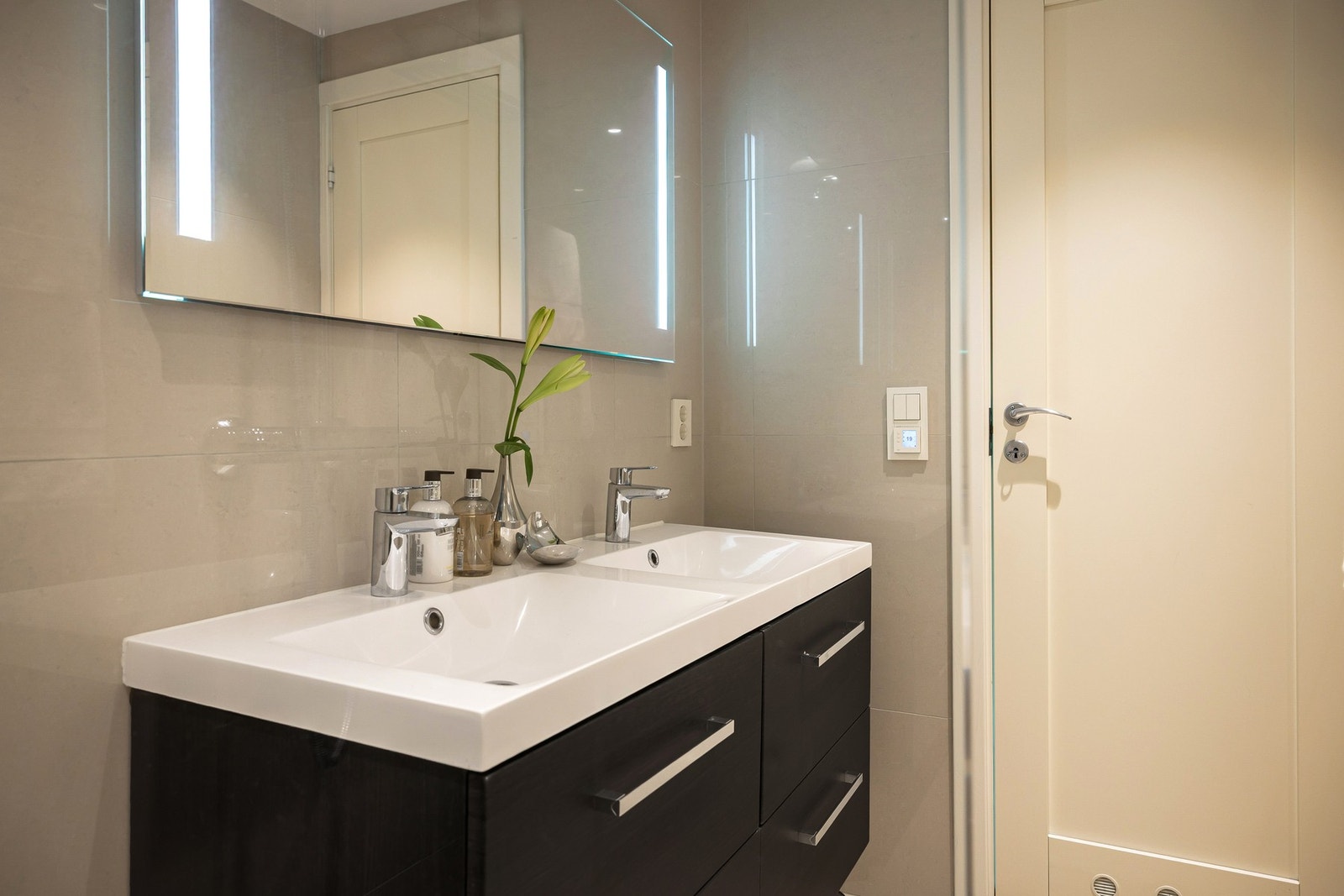 Badet er utstyrt med dusjnisje med regn- og hånddusj, servantinnredning med underskuffer, samt elektrisk håndkletørker. Galleribilde