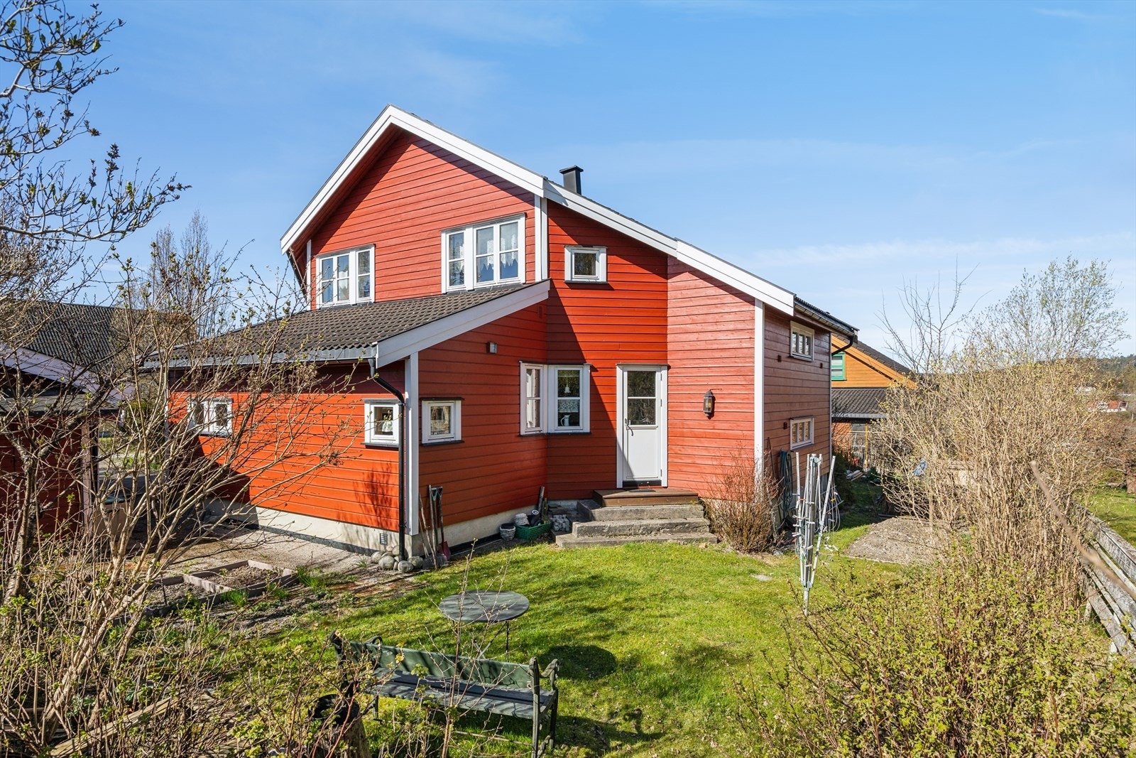 Eneboligen har en stor hage med plen og beplantning. Galleribilde