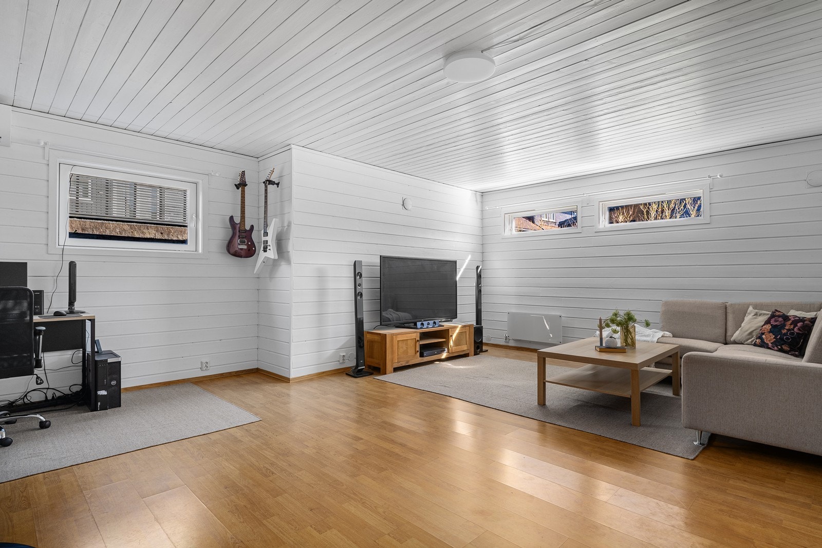 En romslig kjellerstue med pass til sofagruppe og arbeidspult. Galleribilde